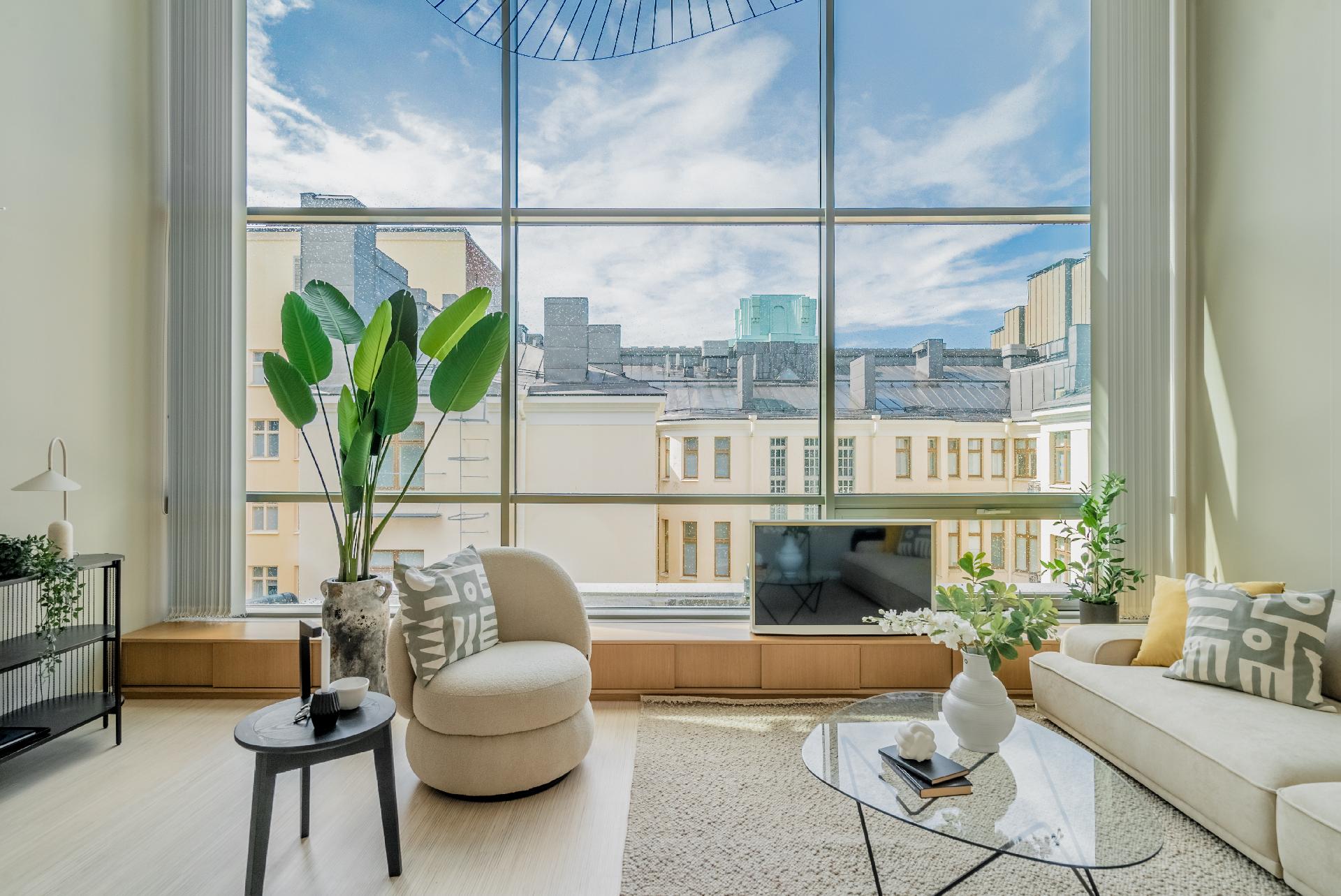 Kahden kerroksen korkuinen ja koko olohuoneen levyinen ikkunaseinä antaa huoneistolle ainutlaatuisen ilmeen.