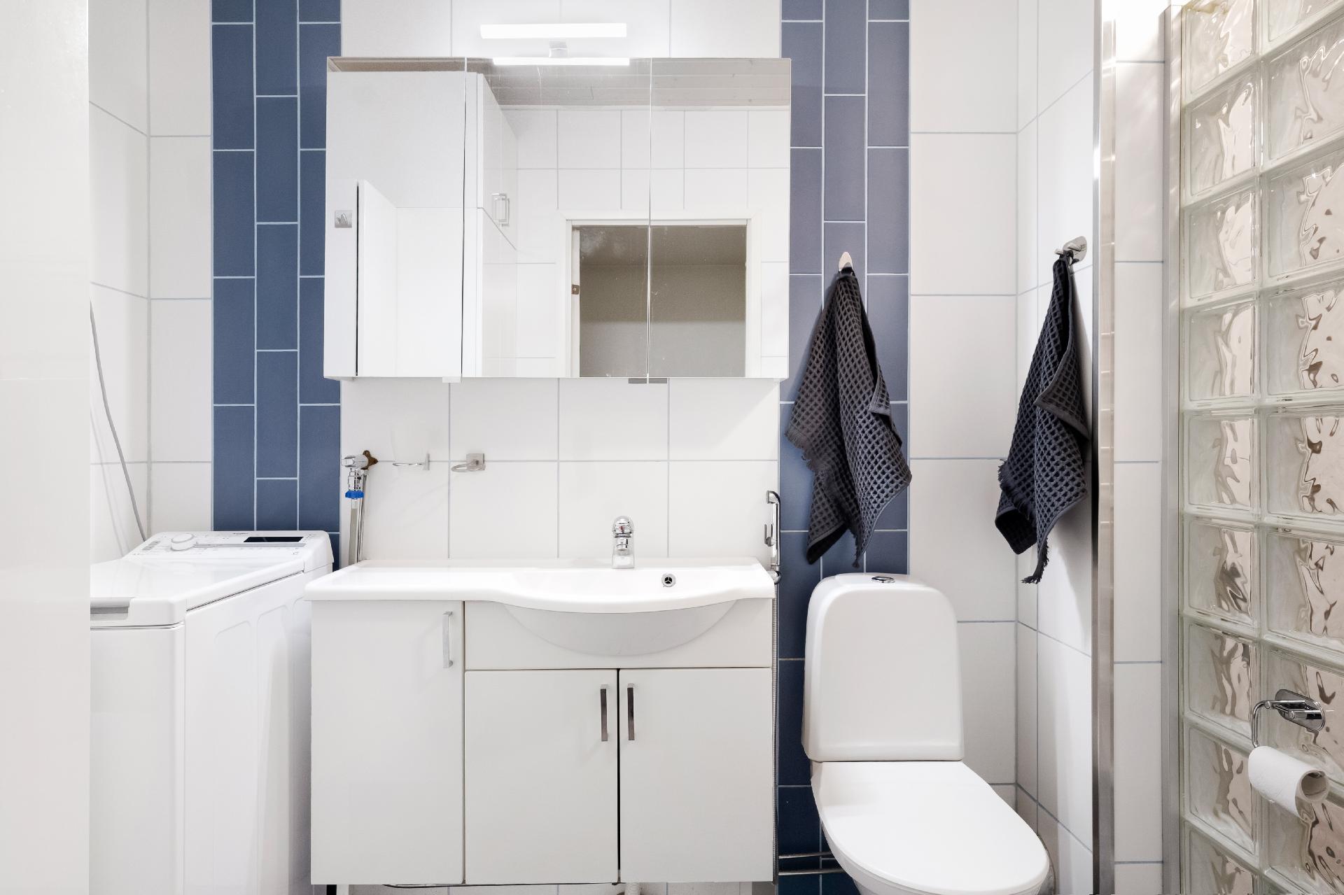 Kylpyhuone on sinivalkoinen ja sinne mahtuu hyvin pyykkikone.
