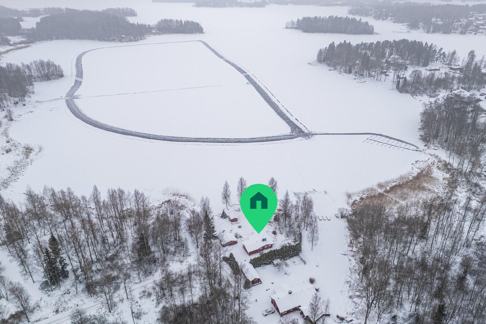 Aurattu luistelurata mökin edessä.