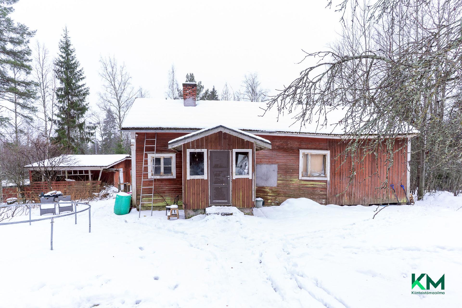 Pihassa vanha purkukuntoinen asuinrakennus, joka toimii varastona