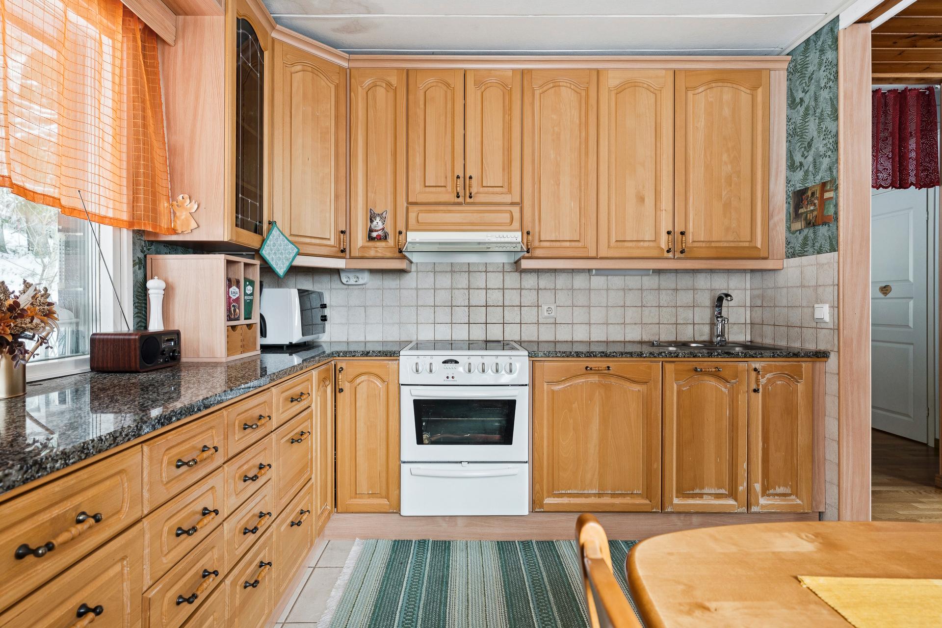 Perinteikäs keittiö tyylikkäillä kivitasoilla