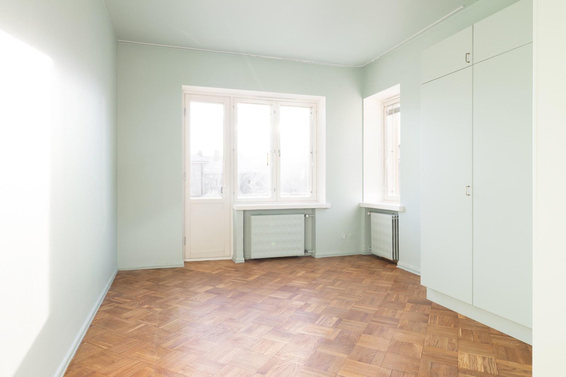 Tilava makuuhuone, jossa parveke aamuaurinkoon