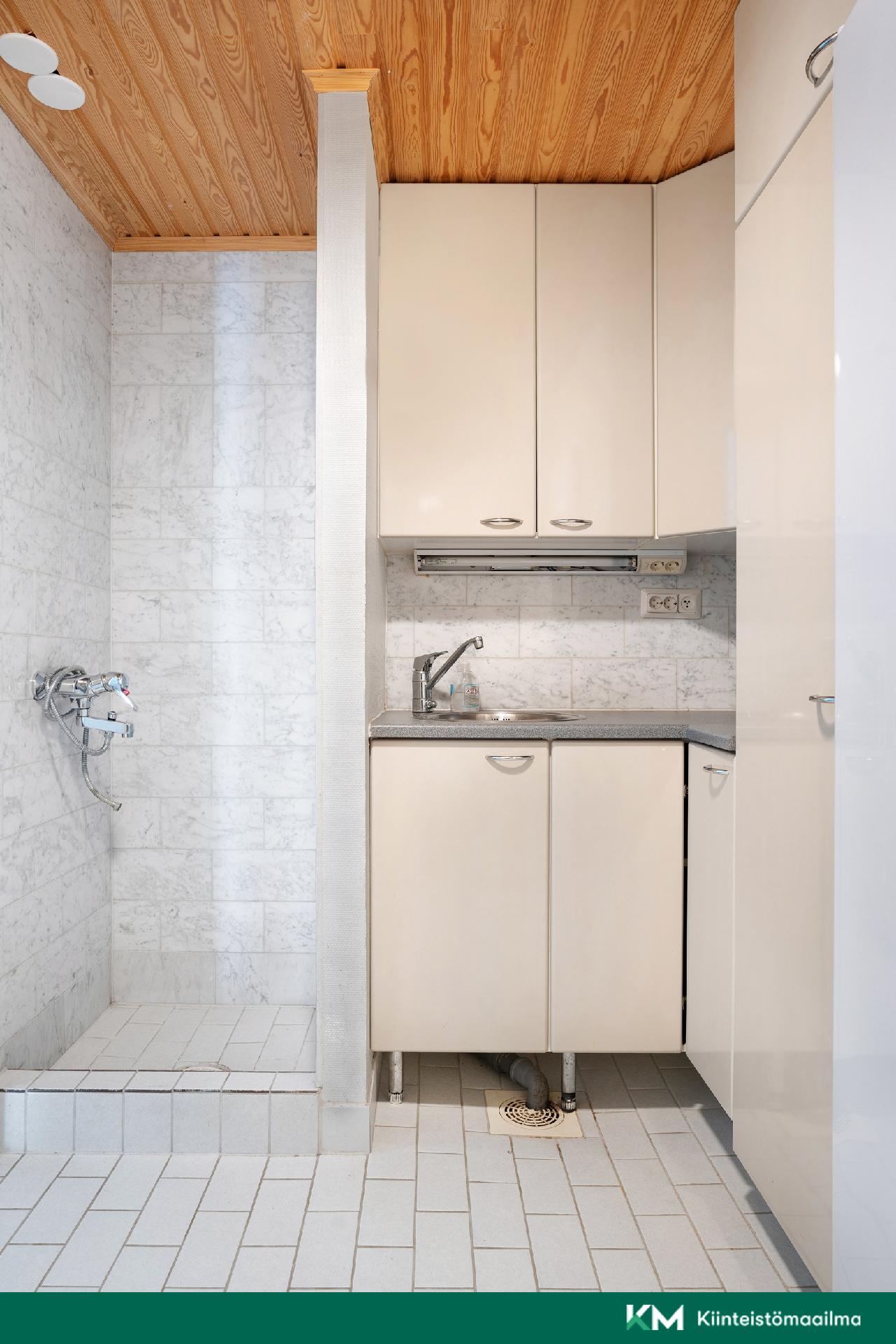 Eteisen vieressä kodinhoitohuone, jossa myös suihkutila