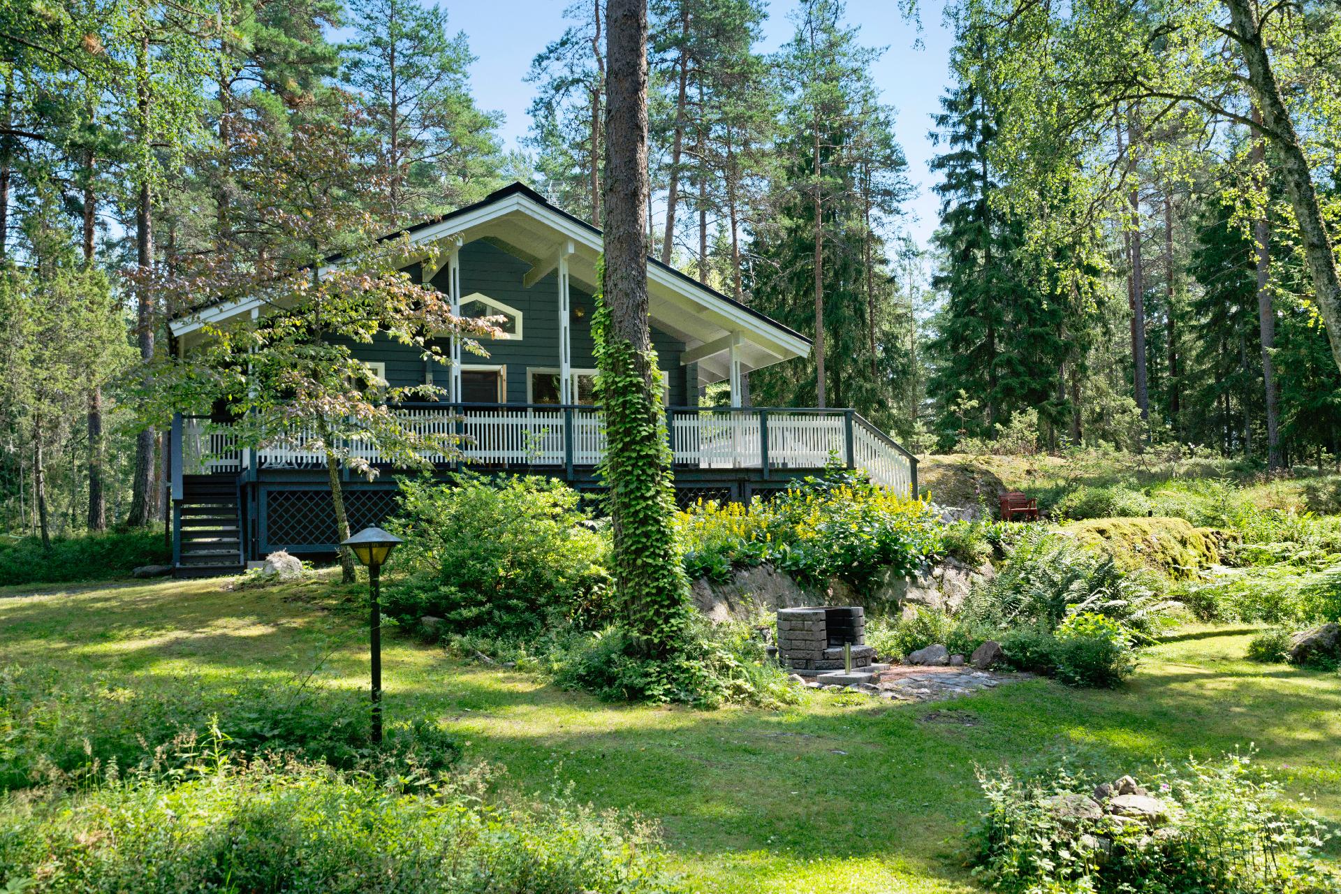 Vehreä ja rauhallinen piha-alue mökin ympärillä– kuva kesältä 2025