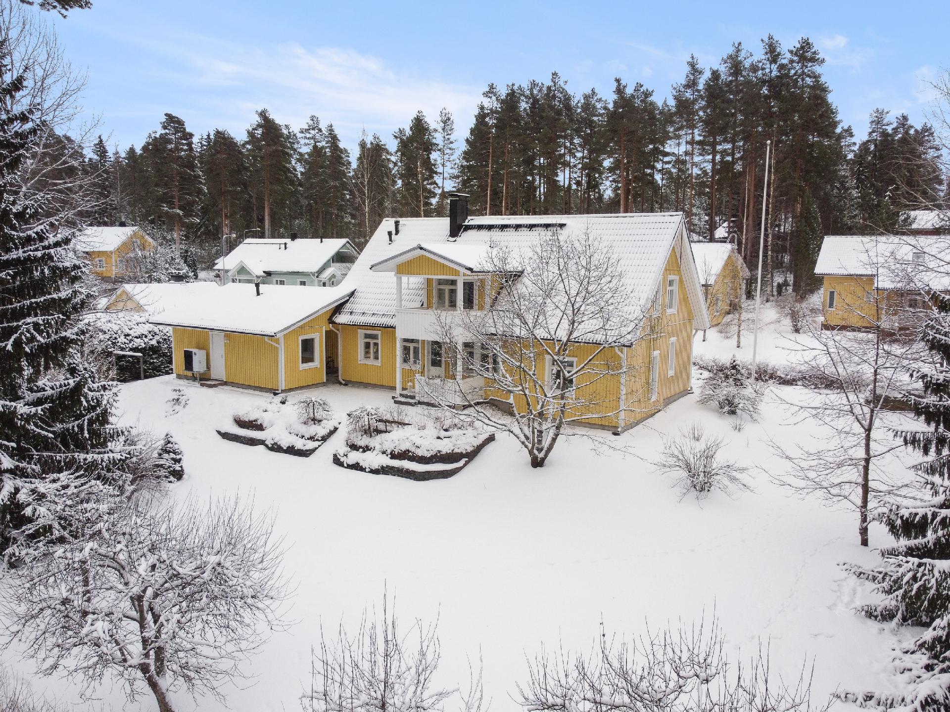 Takapiha on pengerretty. Terassi on tilava. Terassin edessä on mm. kirsikkapuu.