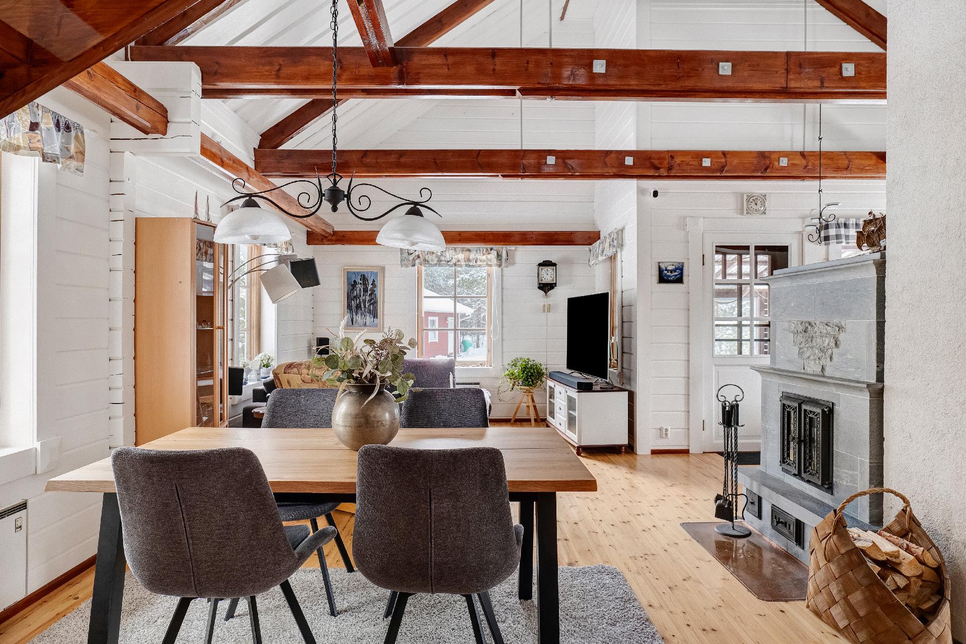 Keittiö ja ruokailutila avautuvat olohuoneeseen, jossa tunnelmaa luo kaunis vuolukivitakka