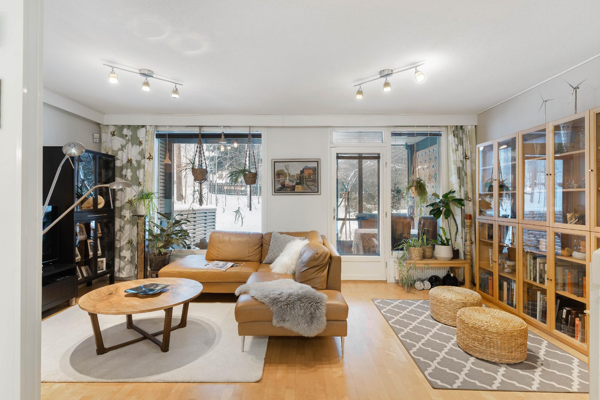 Olohuoneesta käynti lasitetulle terassille, katetun pergolan kautta pihalle.