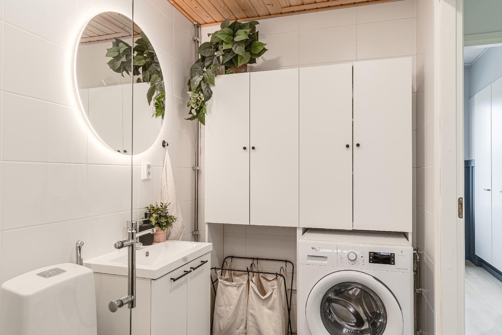 Pesukoneen ympärillä erillinen kaappi, ilman sitä tilaa myös pesutornille