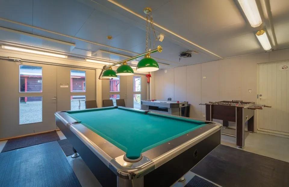Autokatoksen/tallin alapuolella oleva biljardihuone/varastotila, jossa säteilylämmittimet katossa.