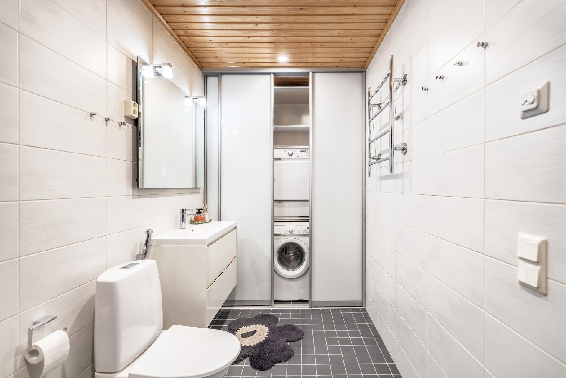 Kylpyhuoneessa pesukoneet ja tekniikka piilossa liukuovien takana