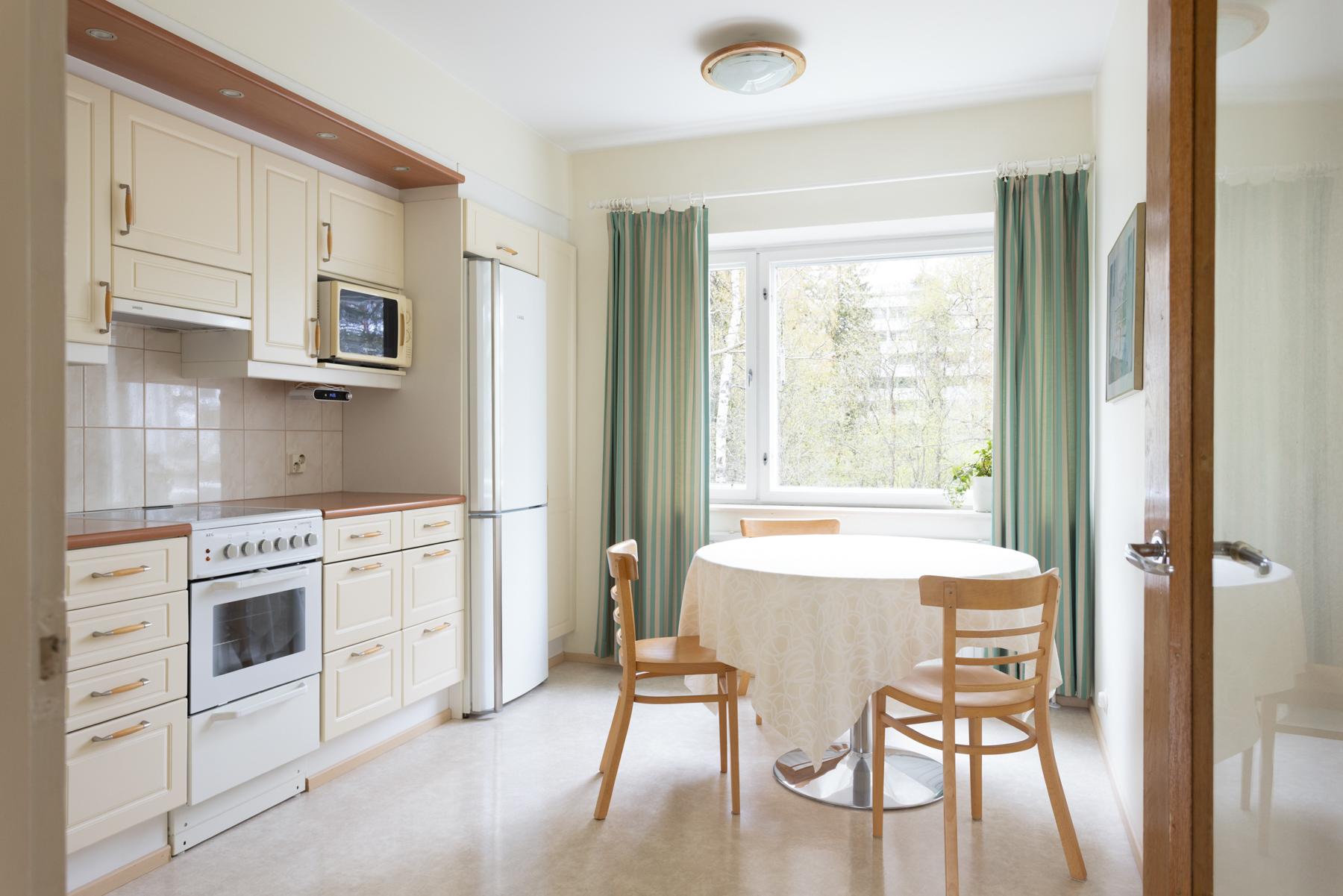 Tilava keittiö, johon mahtuu perheen ruokapöytä