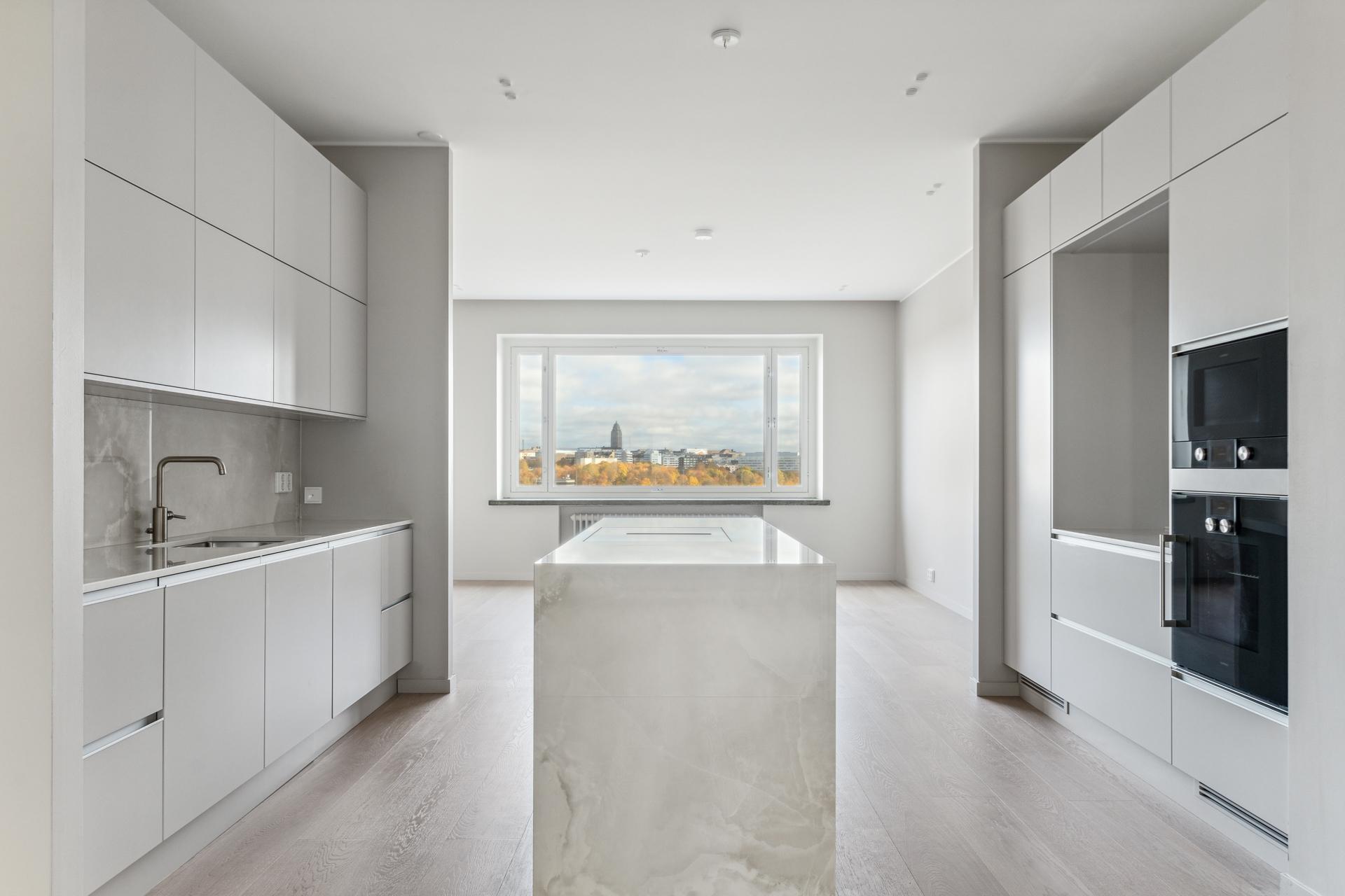 Korkealuokkainen keittiö ruokailutilan ja olohuoneen välissä