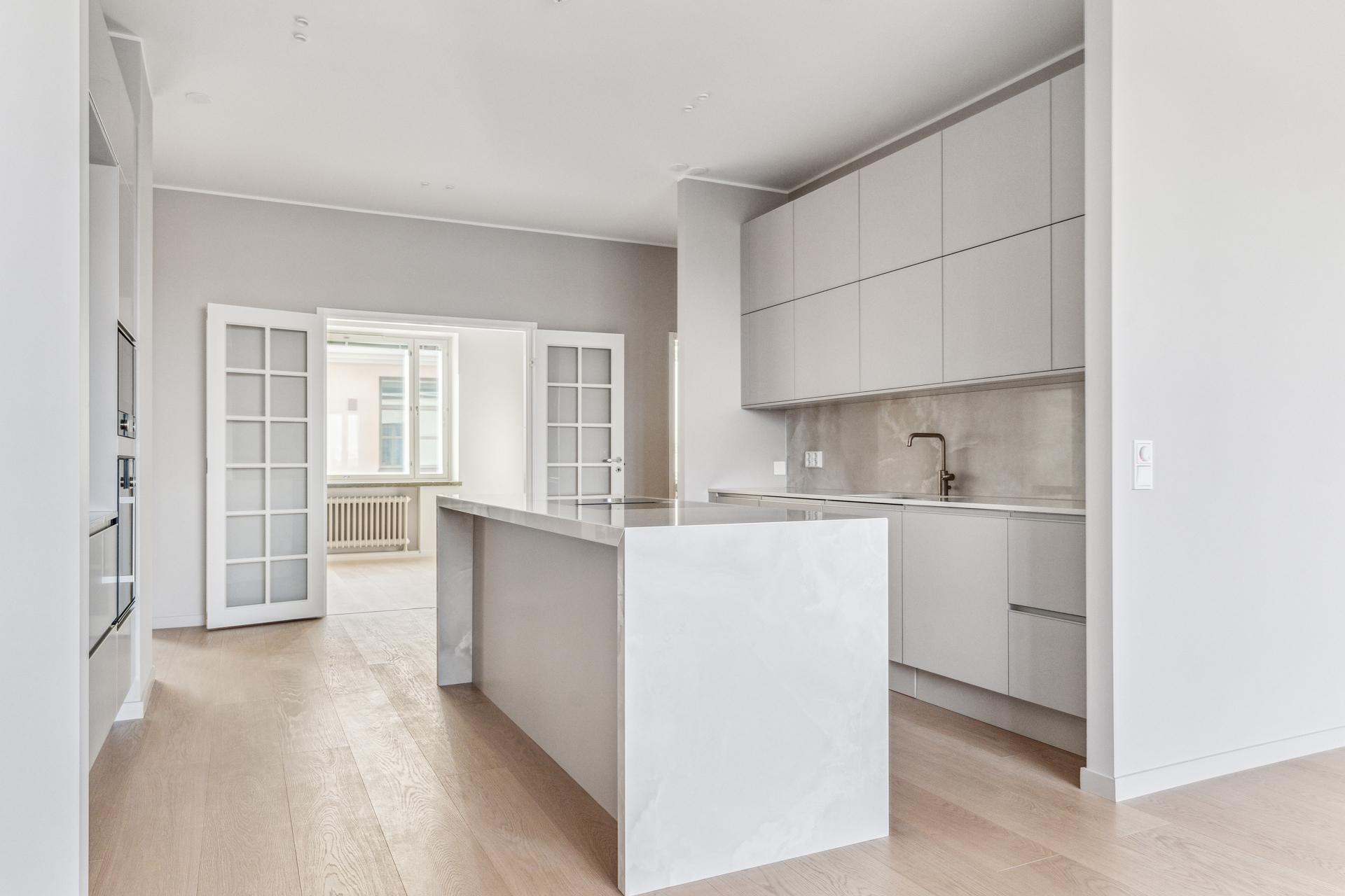 Keittiön toisella puolella lasiovilla suljettava ruokailutila/makuuhuone