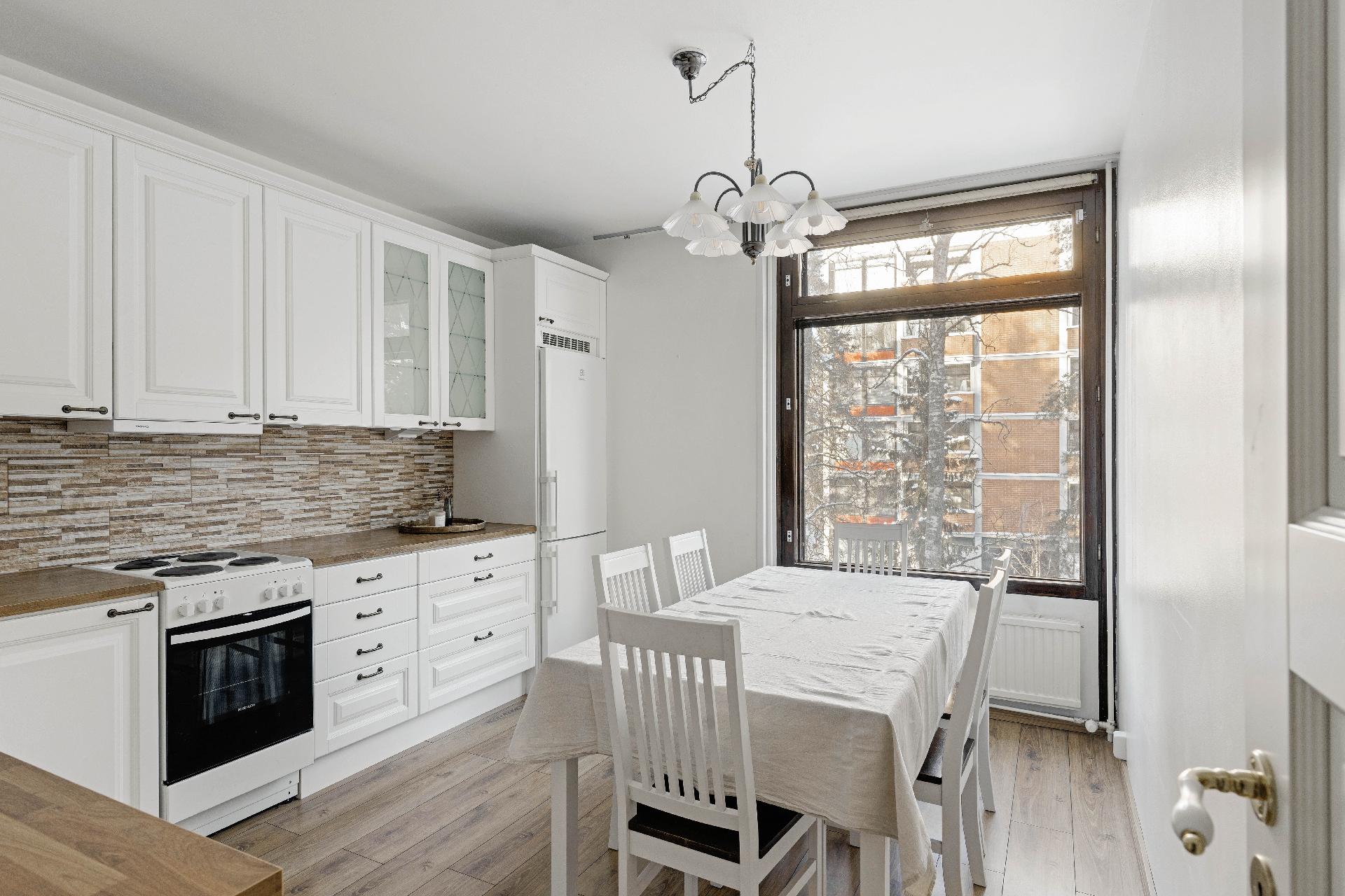 Keittiössä hyvä tila suurellekin ruokapöydälle.