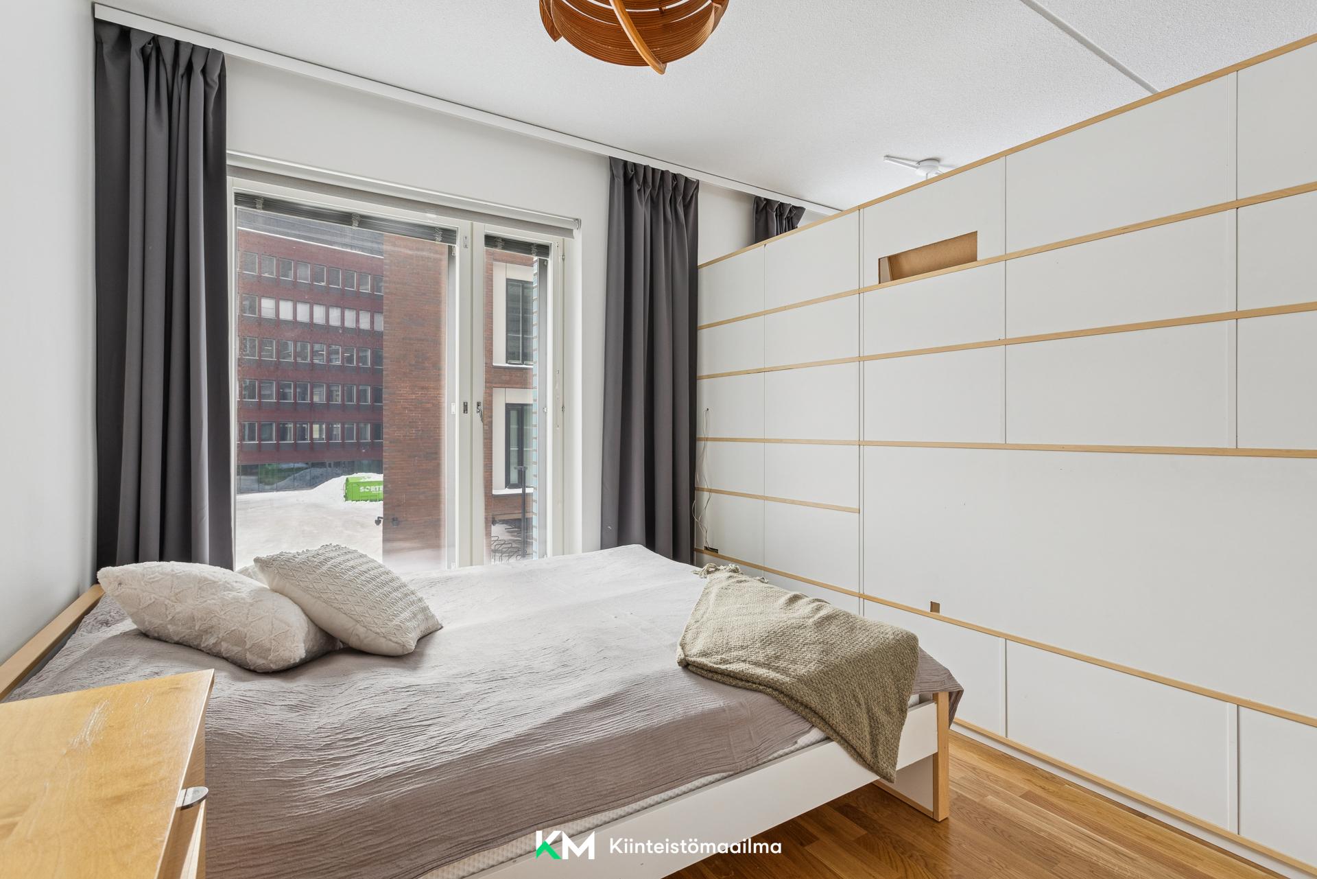 Makuuhuonetila jaettu kirjahyllyllä