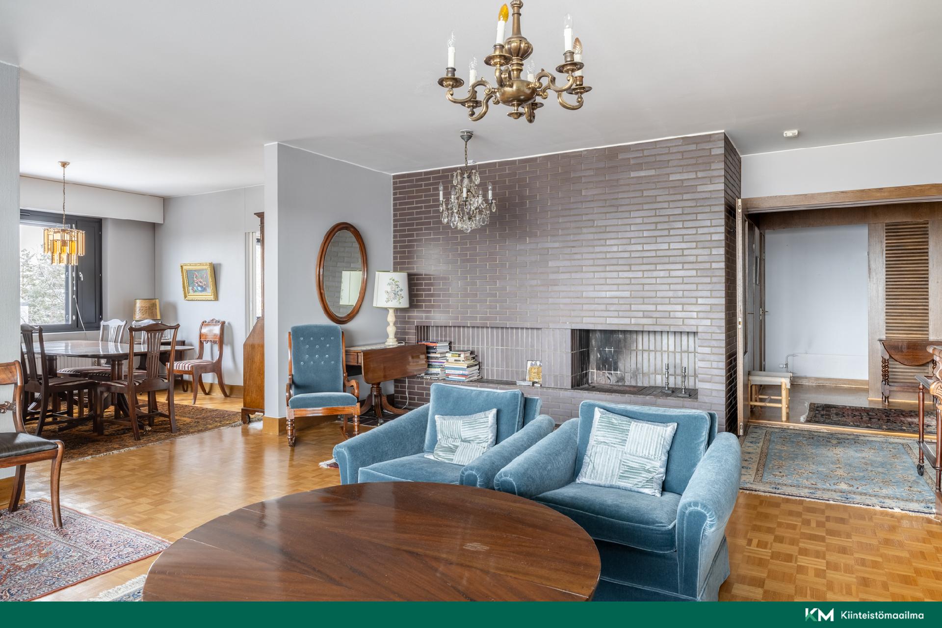 Avara ja valoisa olohuone, jossa tunnelmallinen takka ja tilaa oleskeluun sekä ruokailuun.