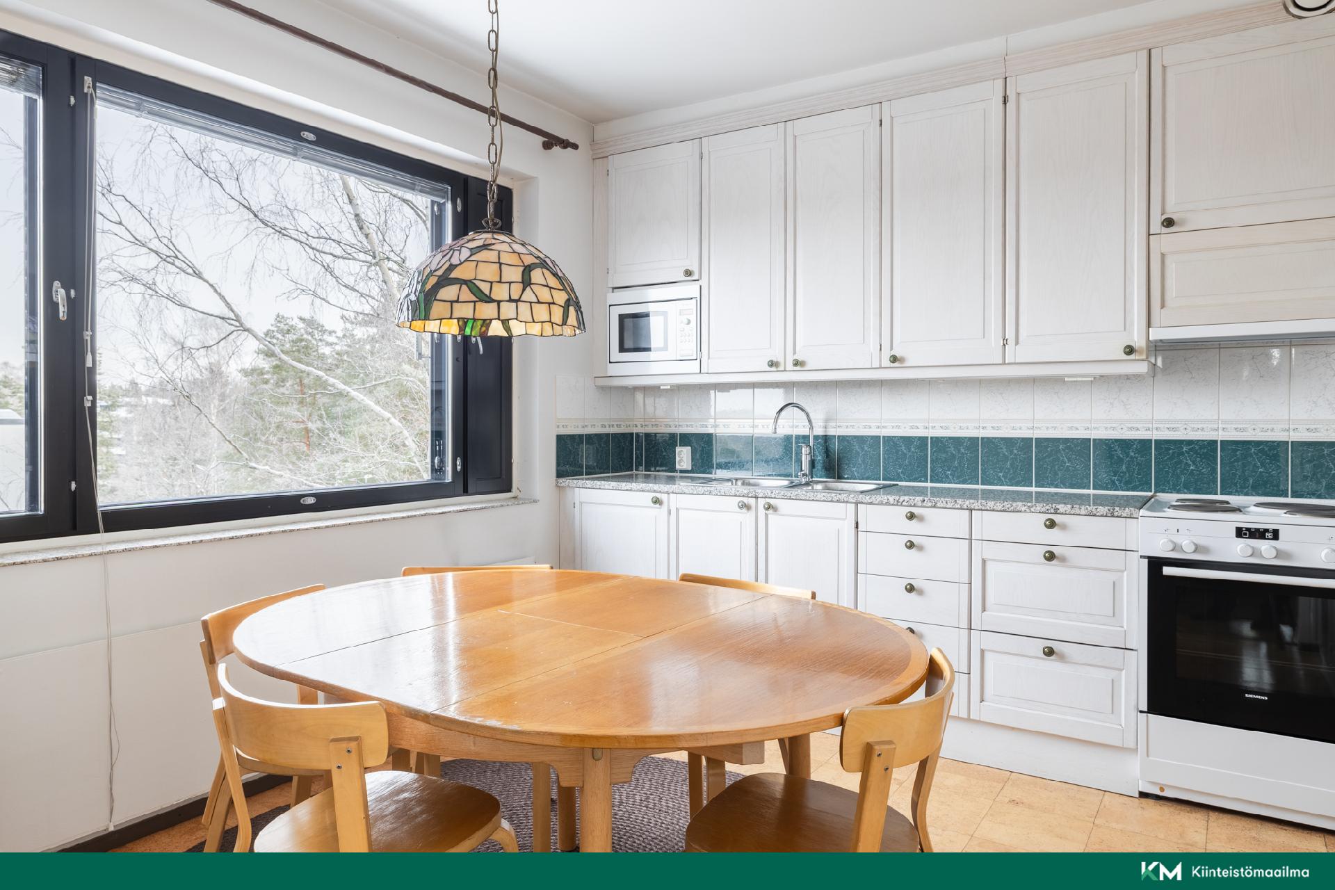 Avarassa keittiössä on tilaa kokkailla yhdessä, ja ruokapöydän ääreen mahtuu isompikin seurue viihtymään.