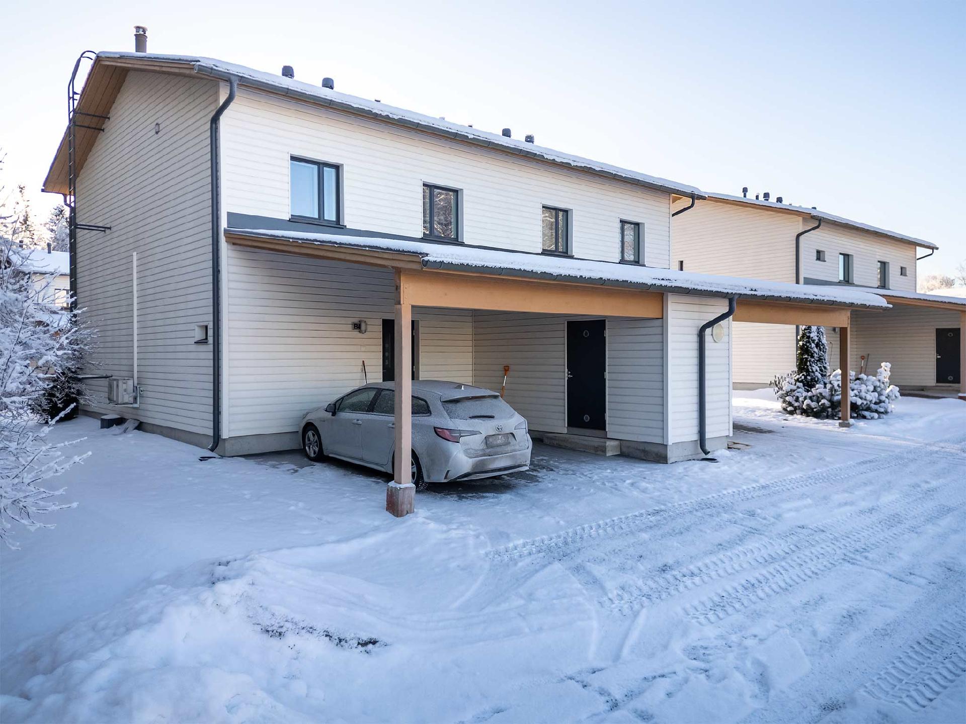 Asunnon edessä kaksi katospaikkaa ja lämmin ulkovarasto