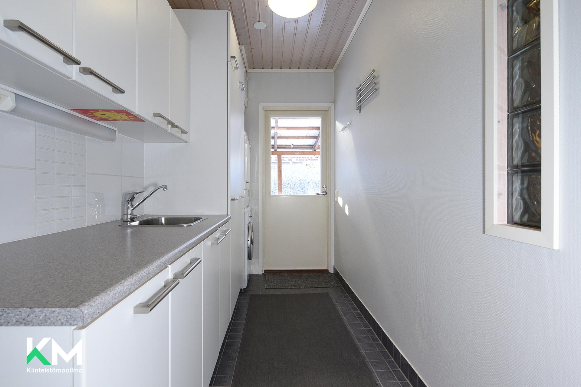 Tilava kodinhoitohuone ja ovi pihalle