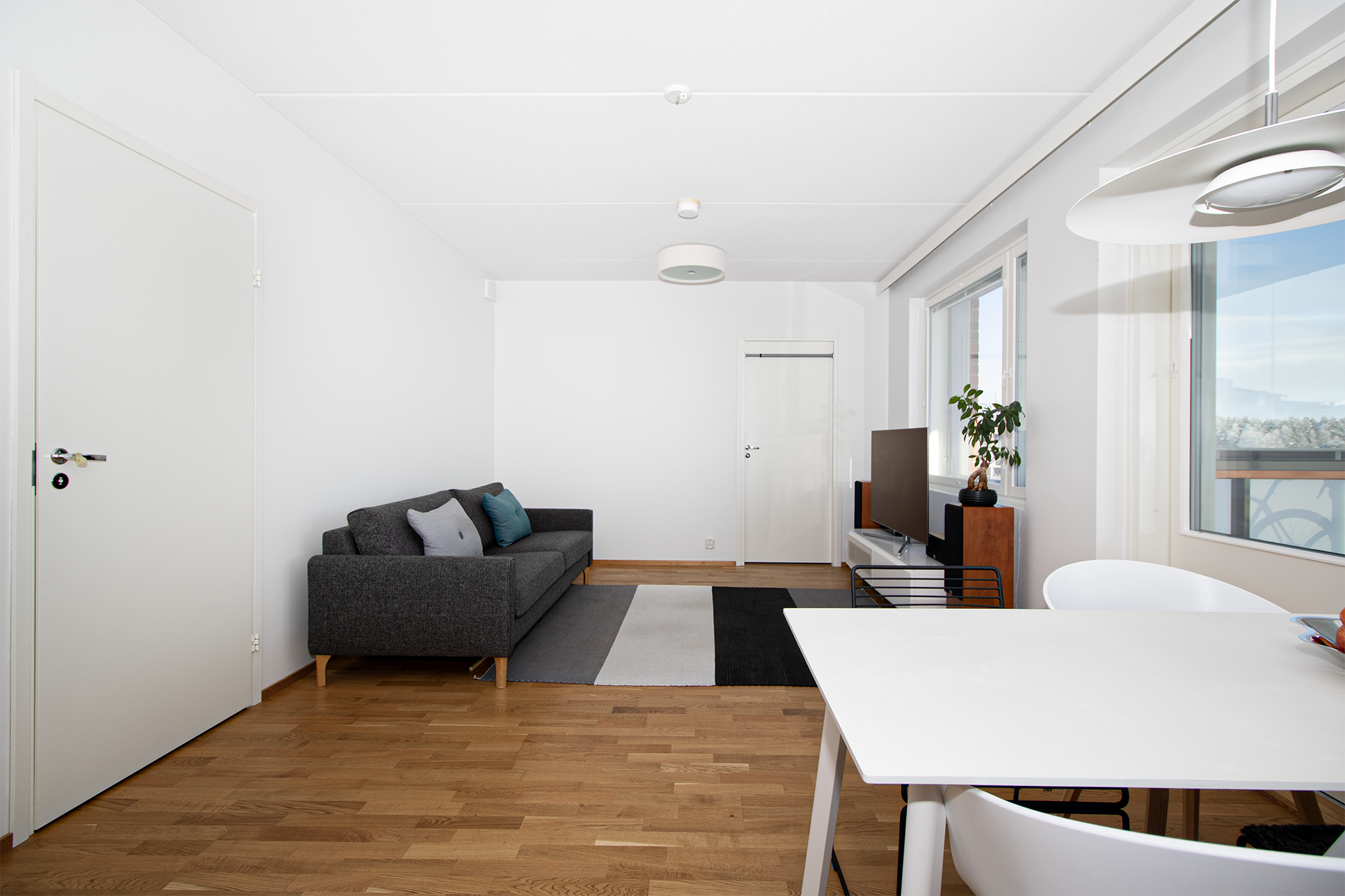 yhtenäinen olohuone/keittiö tila josta käynti lasitetulle terassille ja pihalle     