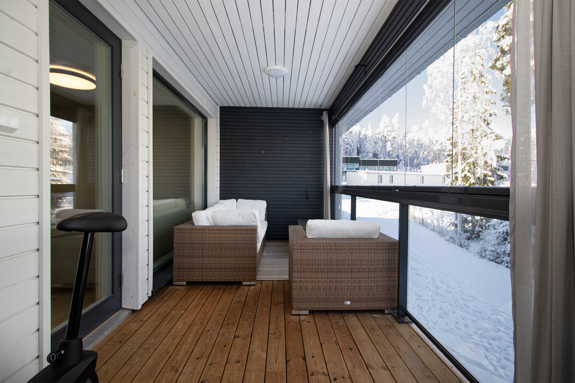 Suuri lasitettu parveke metsäisillä näkymillä.