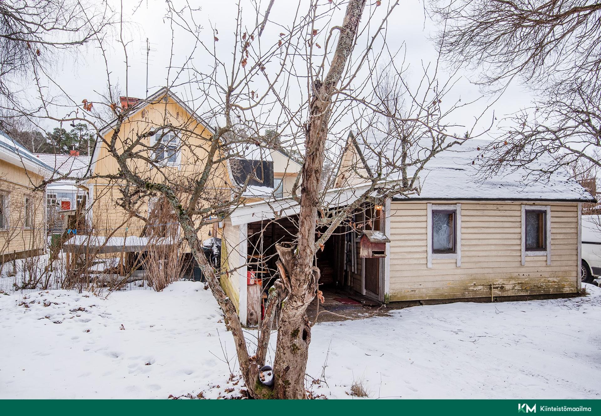 Pihalla purkukuntoinen vanha saunarakennus ja katos