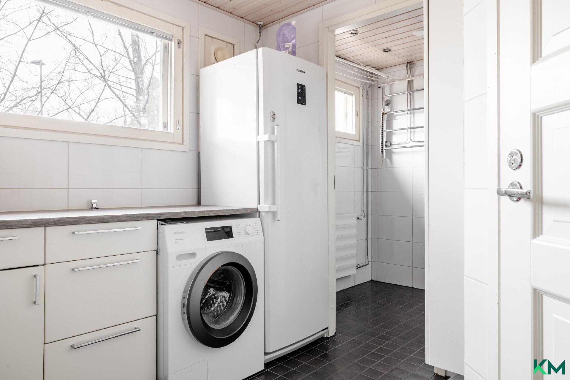 Alakerrassa fiksusti vierekkäin : kodinhoitohuone, wc, kylpyhuone ja sauna.