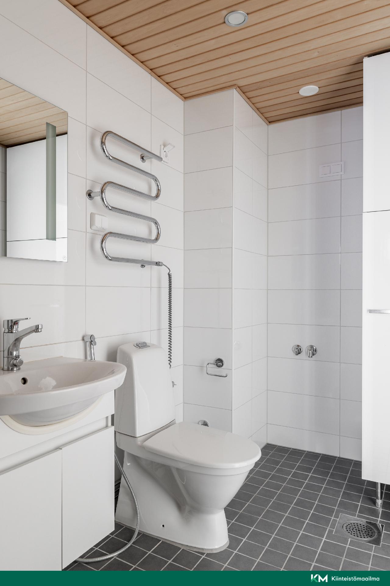 Yläkerran kylpyhuoneessa on paikka pesutornille