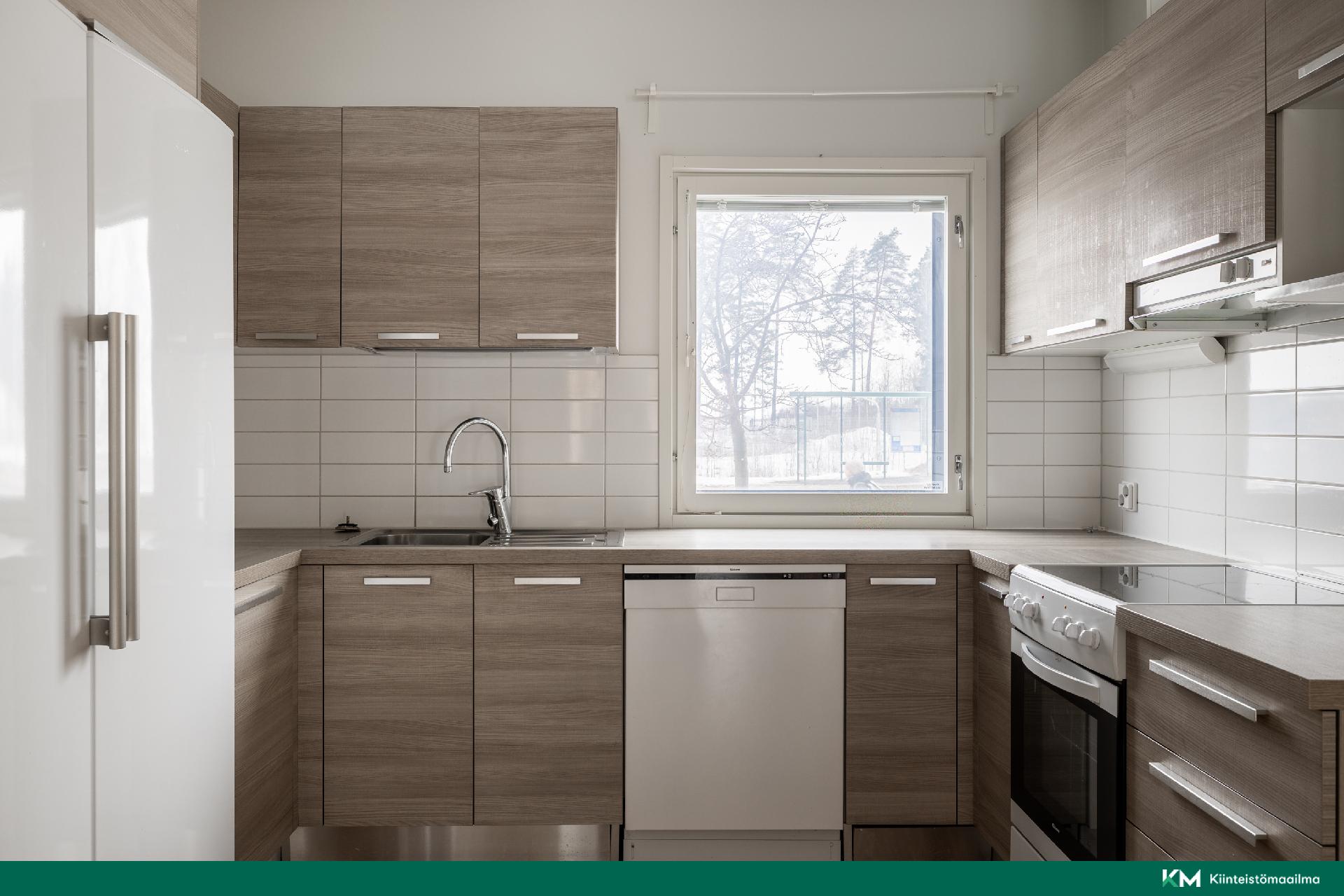 Hyvin varustellussa keittiössä on runsaasti kaappi- ja laskutilaa