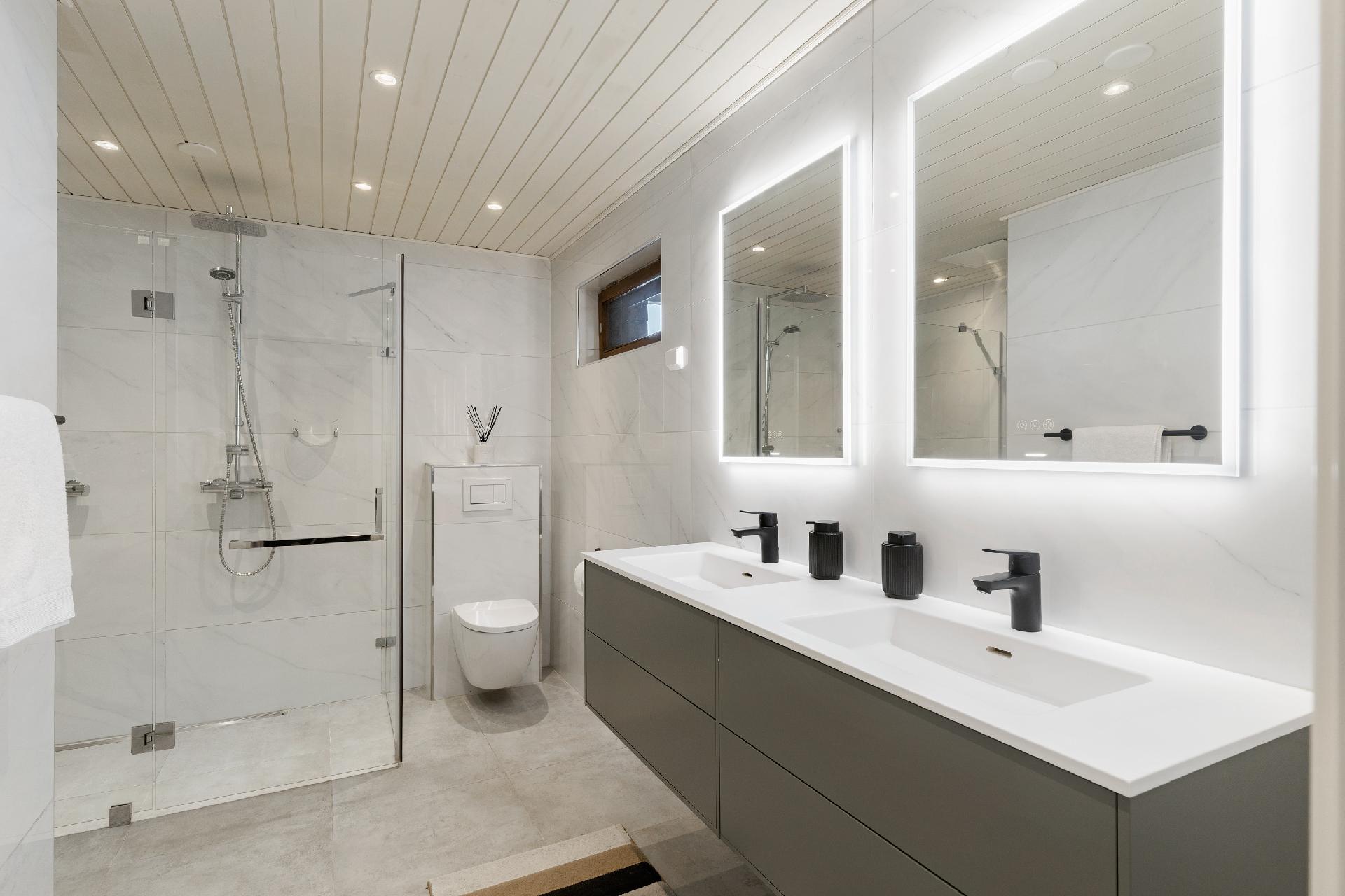 Saunatilojen tilava ja kaunis pesuhuone  kahdella pesualtaalla