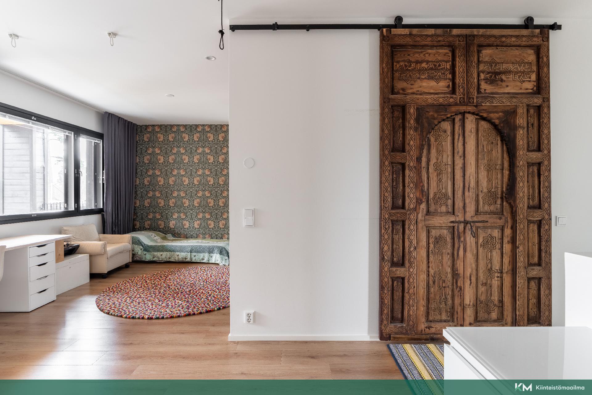 Yläkertaan tultaessa alua sekä marokkolaisen oven takana kodinhoito-saunatilat terasseineen