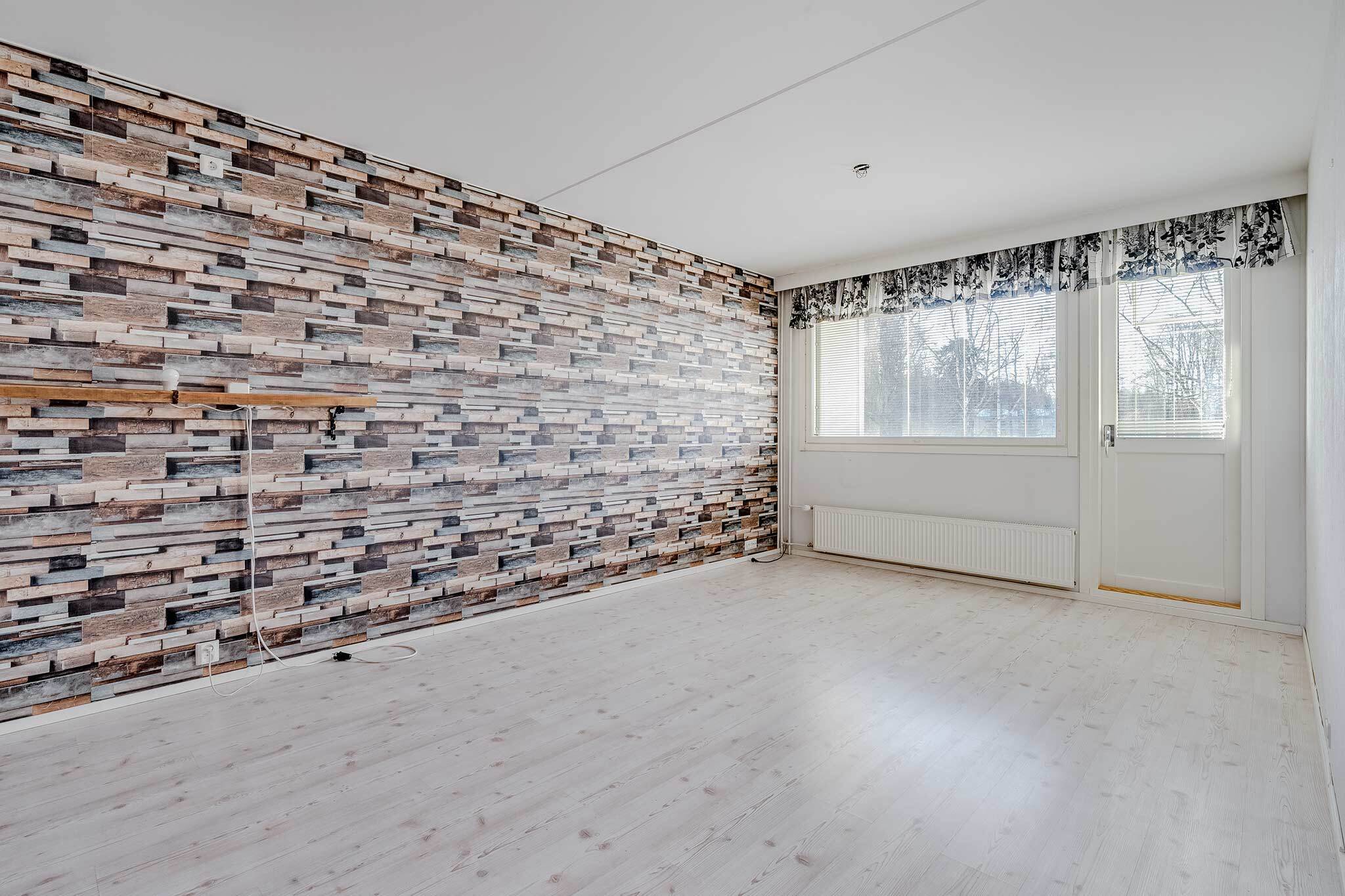 Tilavan olohuoneen seinällä on valokuvatapetti