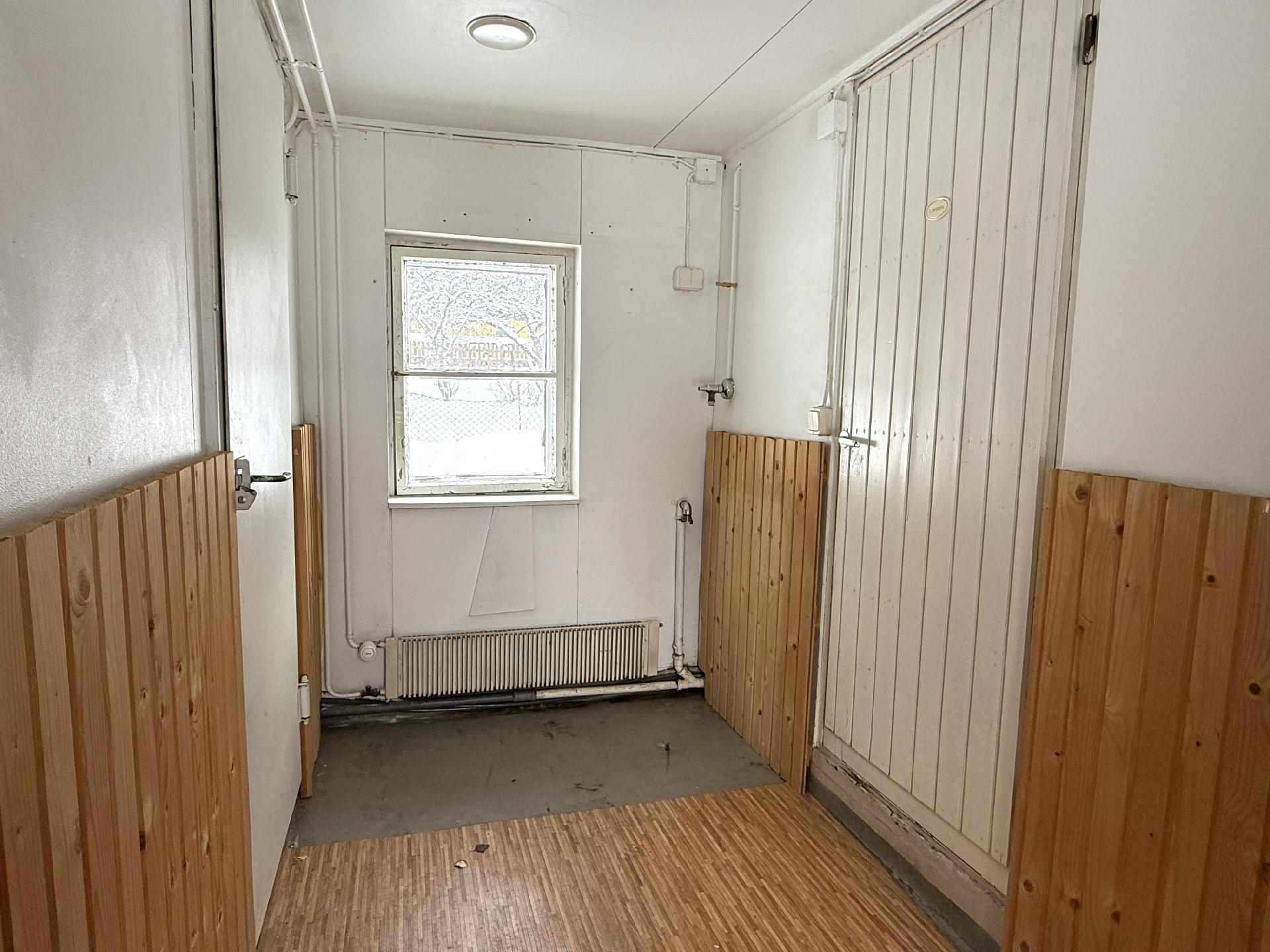 Talousrakennuksessa oleva pukuhuone, missä on pesukoneliitäntä.