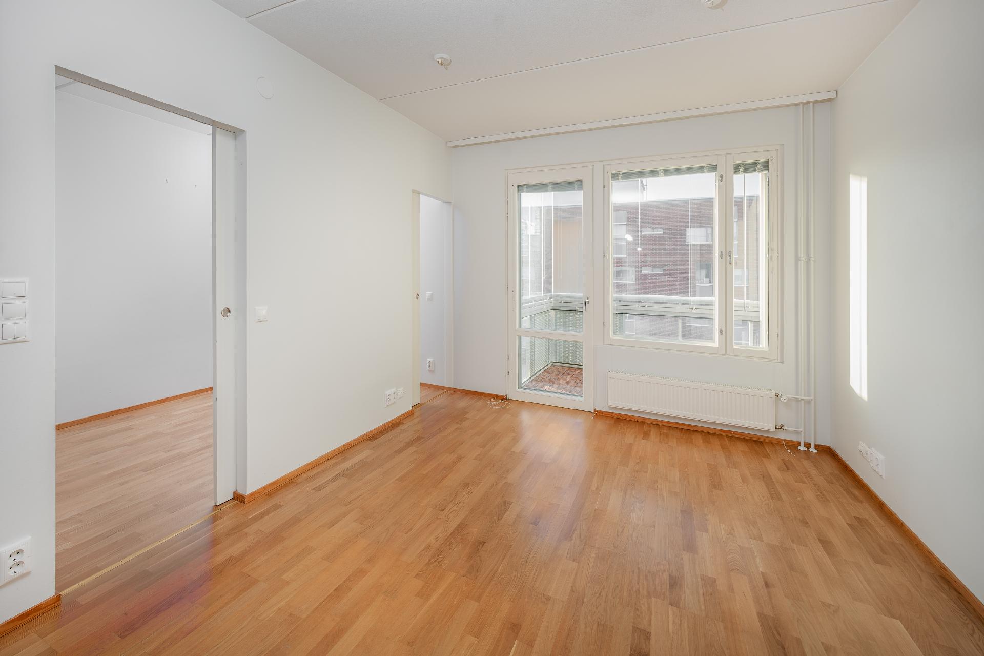 Valoisa olohuone, josta on käynti länsiparvekkeelle