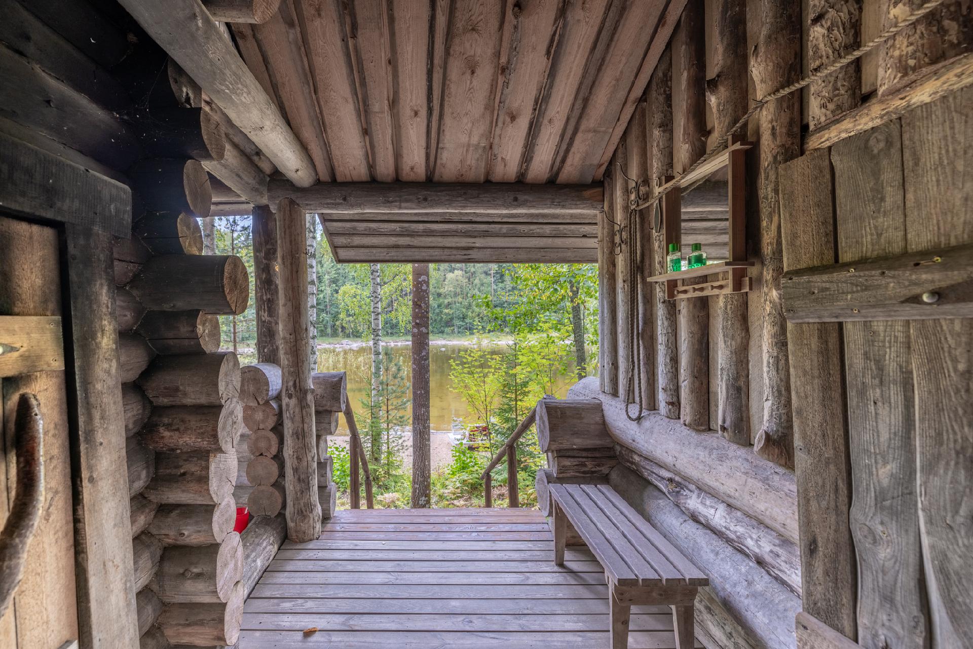 Grillikatoksen ja savusaunan välissä katettu tila, josta lähtee rappuset rantaan.