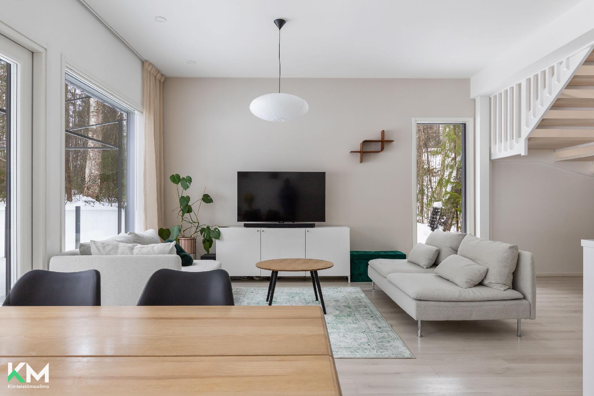 Olohuonekuva, jossa näkyy luonto ikkunoista ja portaikkoa.