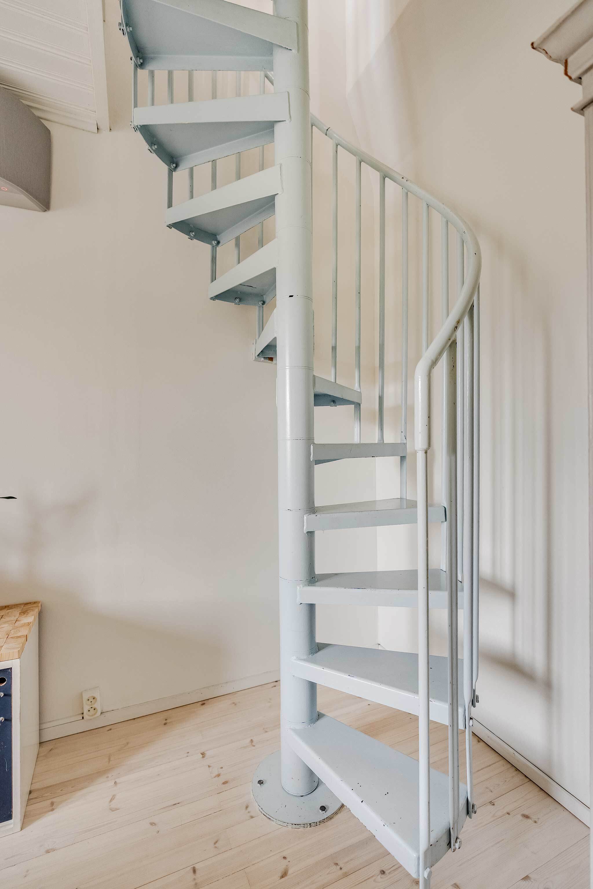 Vaaleansiniset metalliportaat vievät alakerran makuuhuoneeseen