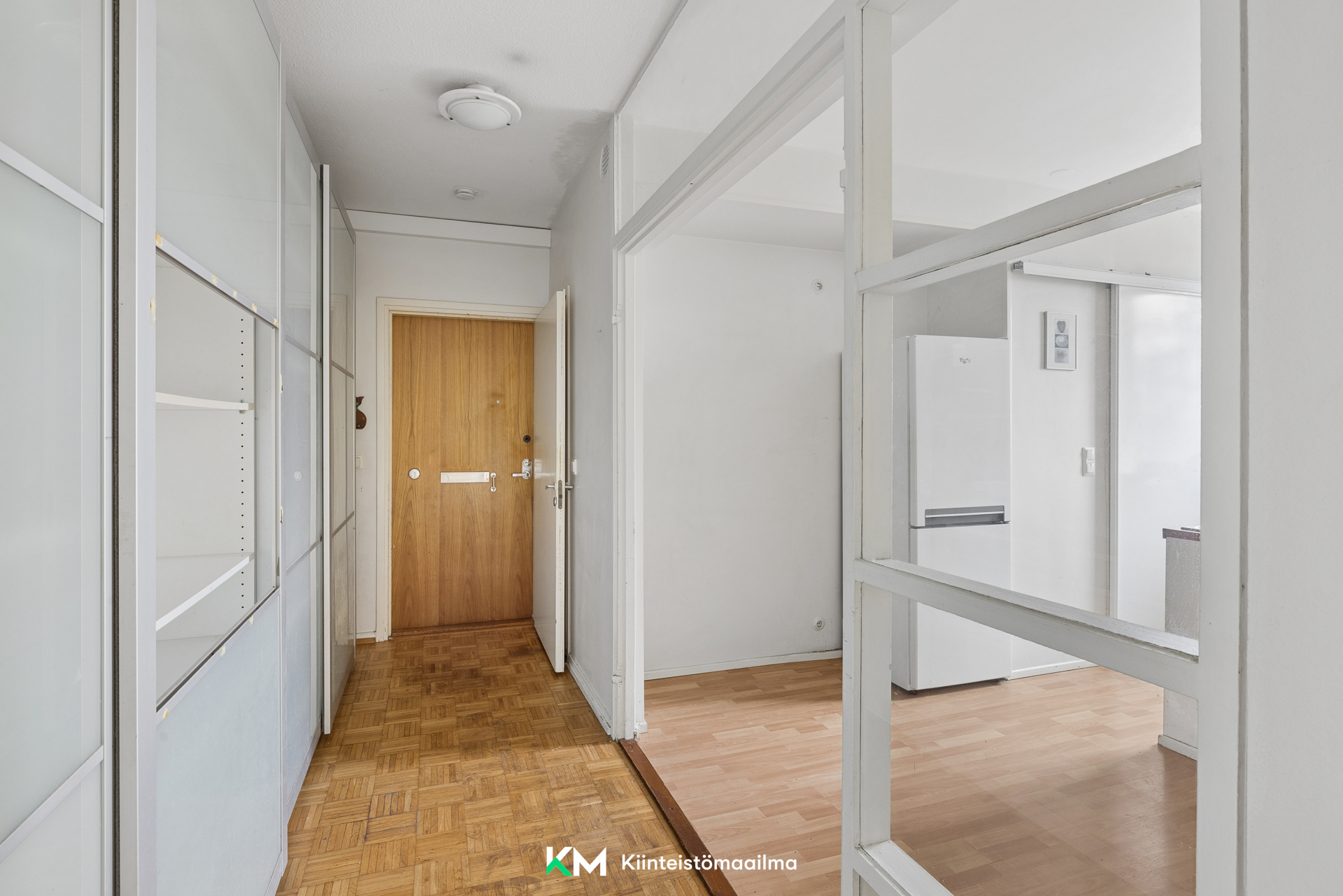 Näkymä olohuoneesta eteiseen, keittiö oikealla