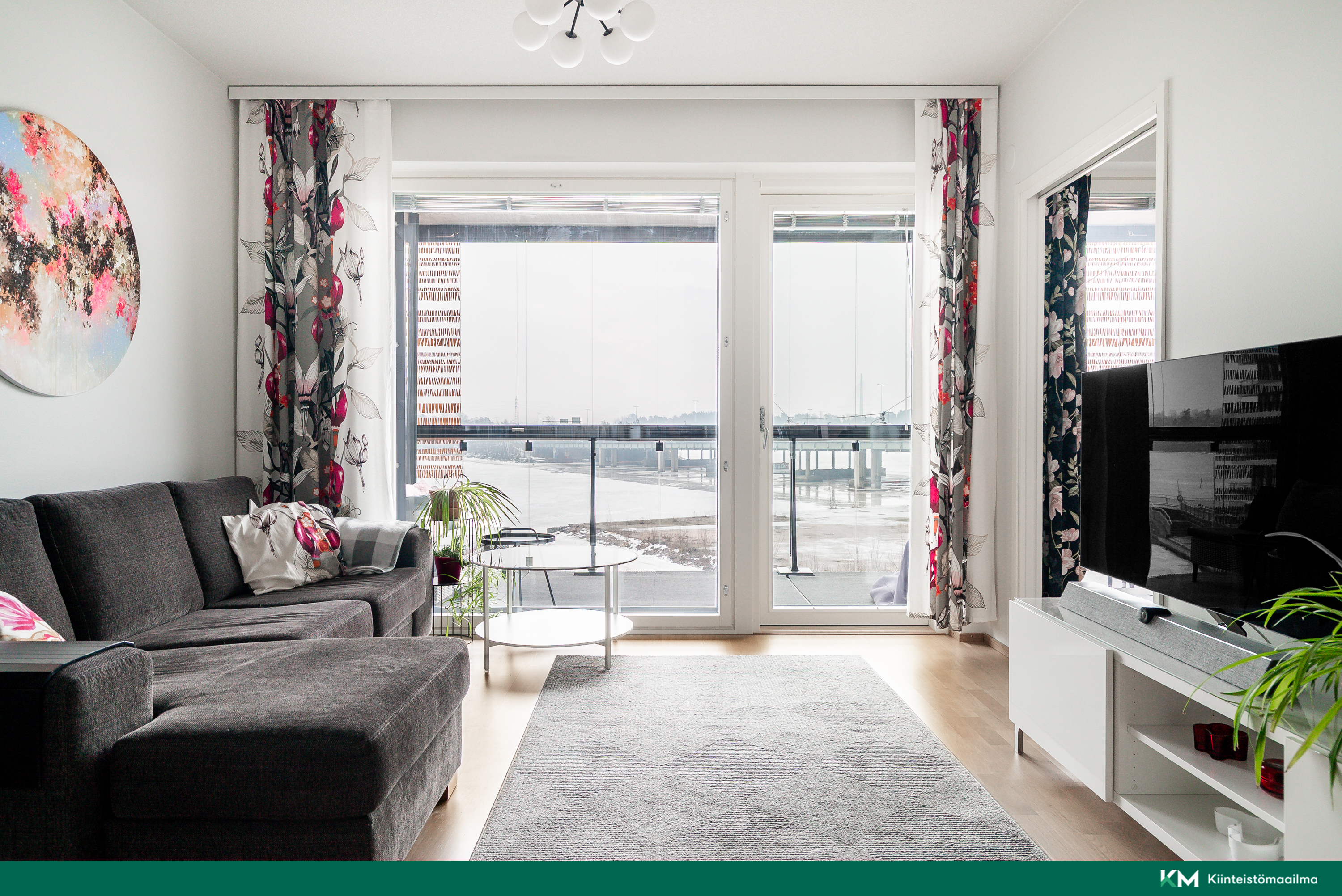 Olohuoneessa isot ikkunat lasitetulle parvekkeelle