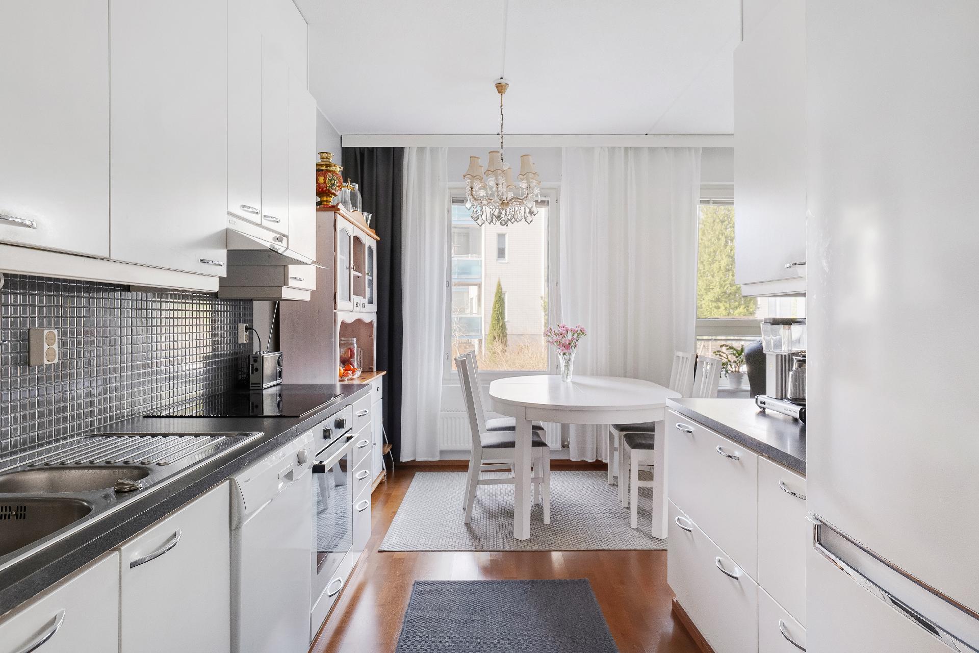 Valoisa keittiö ja ruokailutila, johon mahtuu isompikin ruokapöytä.