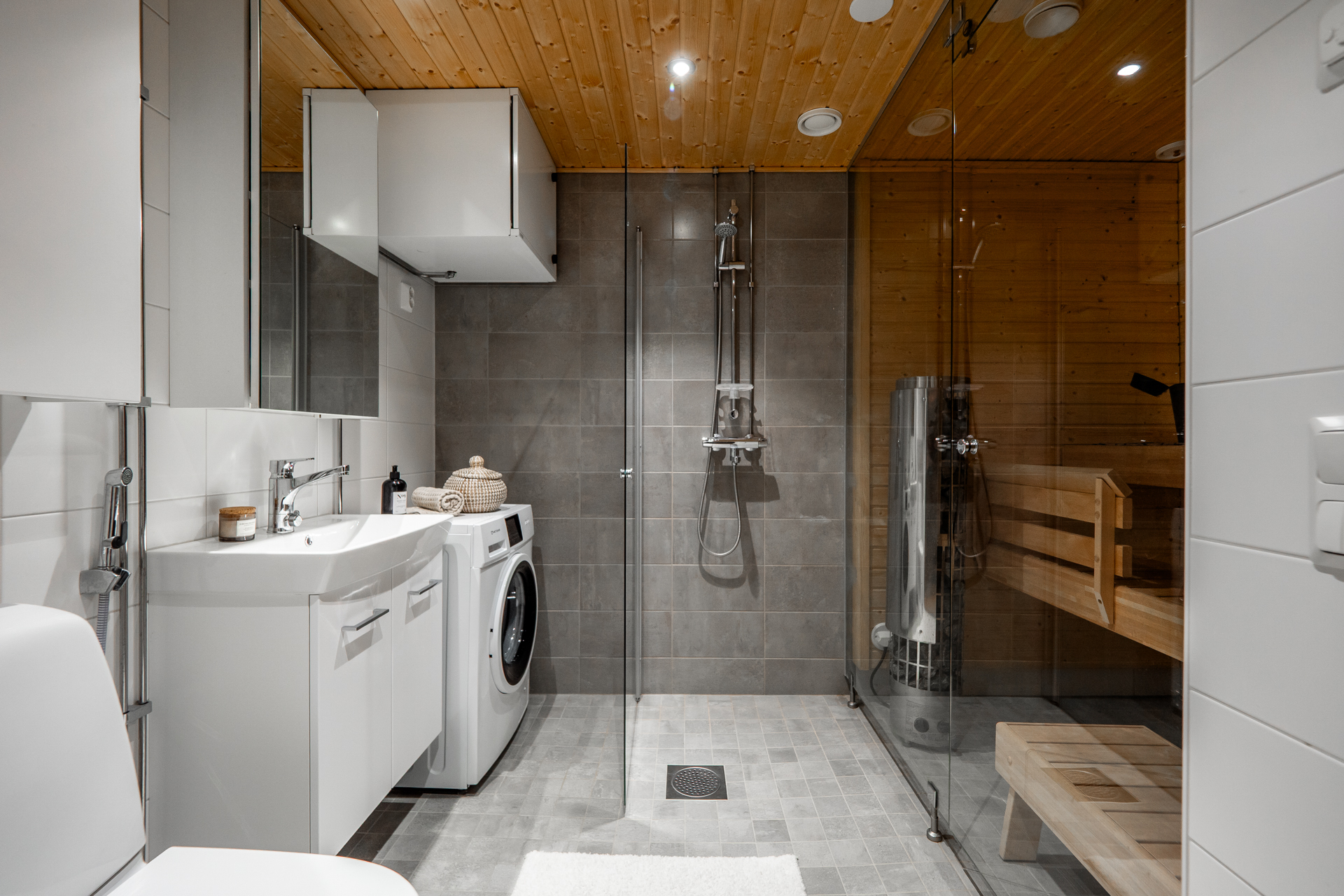 Tyylikäs sauna lasiseinällä ja Harvian pilarikiukaalla.