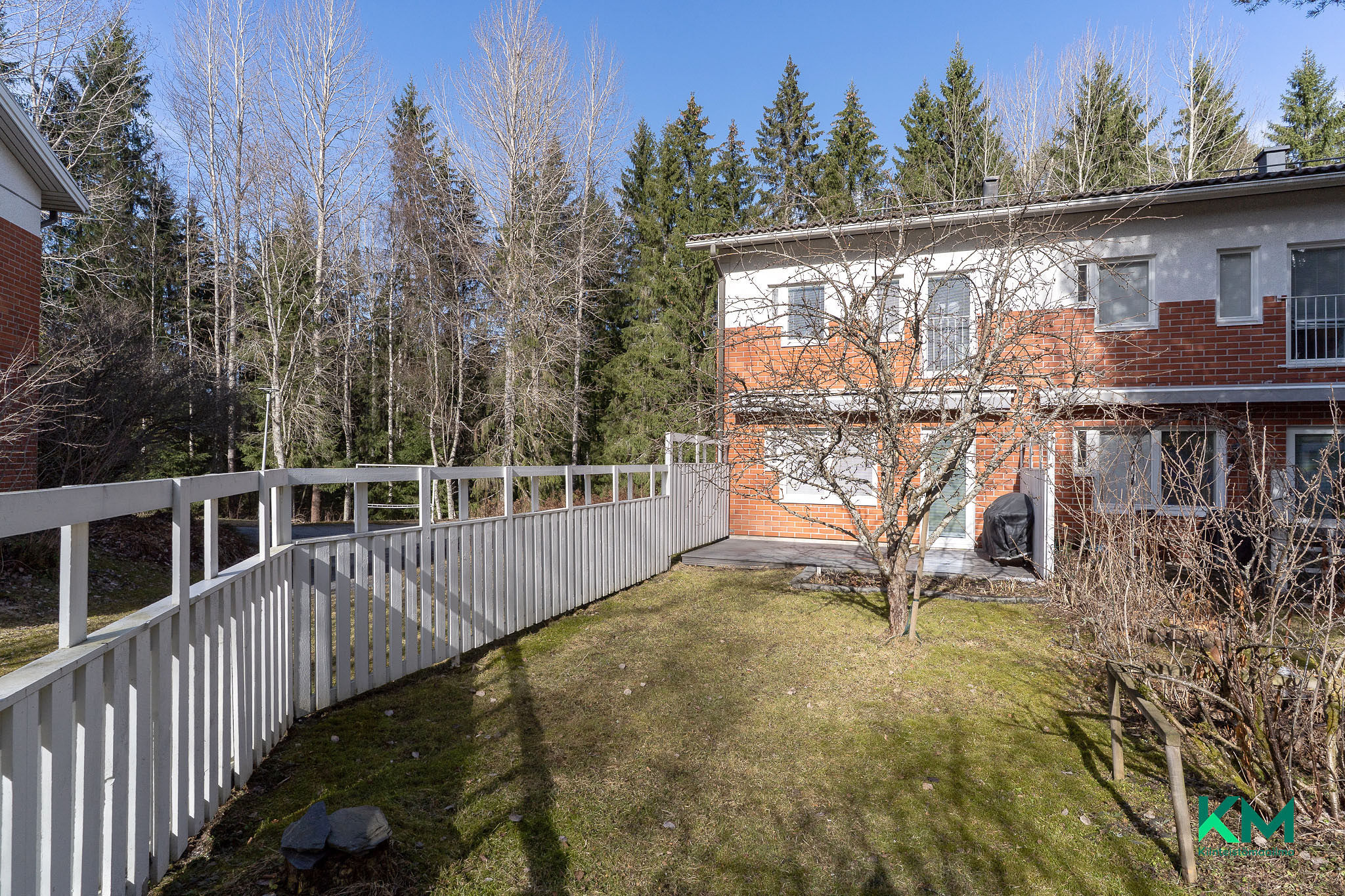 Aurinkoinen takapiha, markiisilla suojaa koko terassin