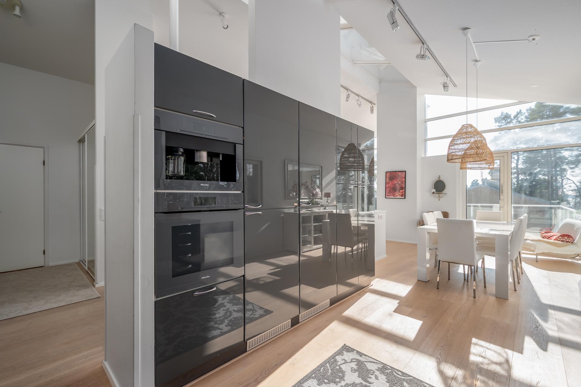 Keittiön jatkeena avautuu viihtyisä ruokailutila, joka mukautuu sujuvasti niin arjen kiireisiin hetkiin kuin juhlavampiin kokoontumisiin
