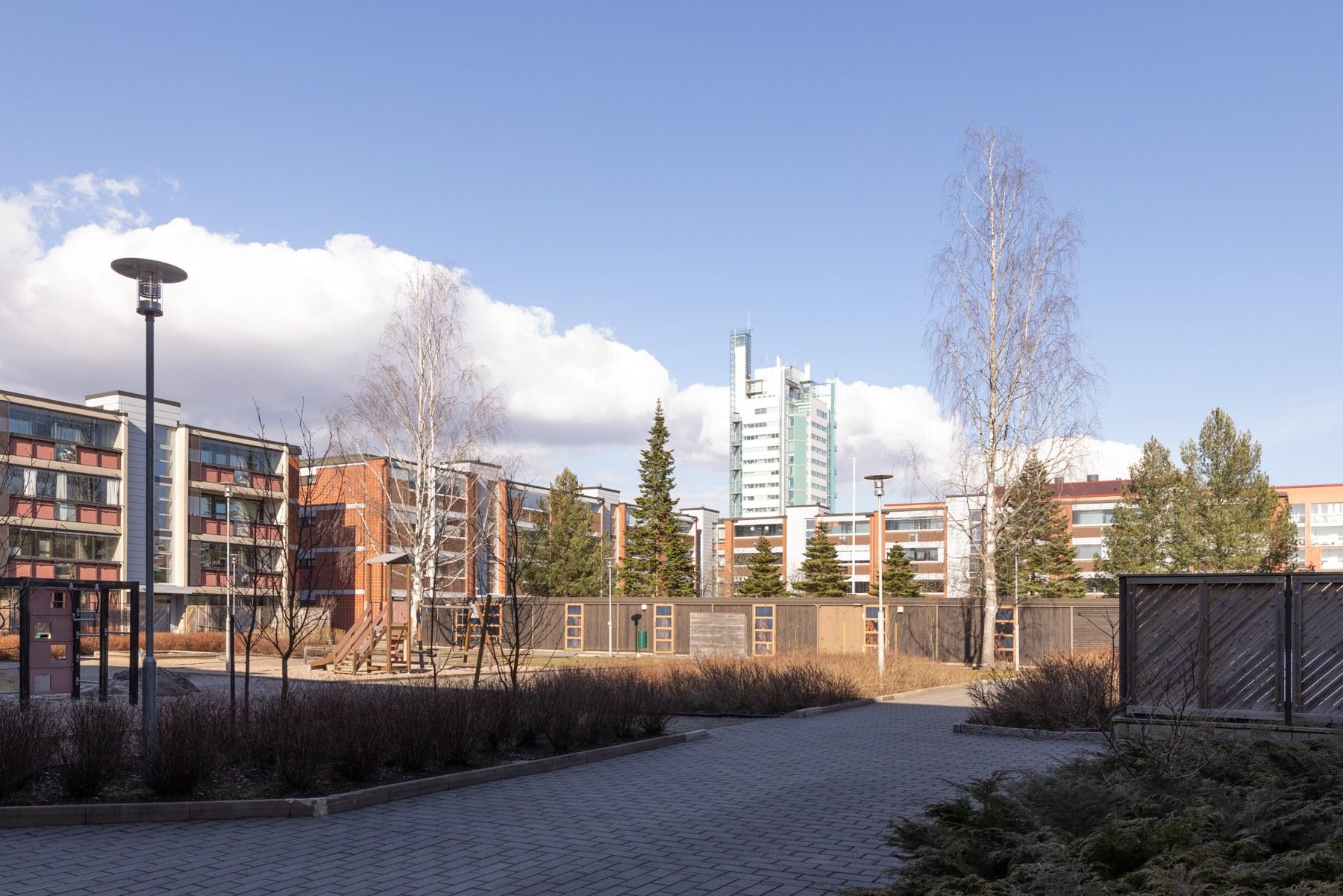 Taloyhtiön piha-aluetta - taustalla Itäkeskuksen maamerkki Helmitorni