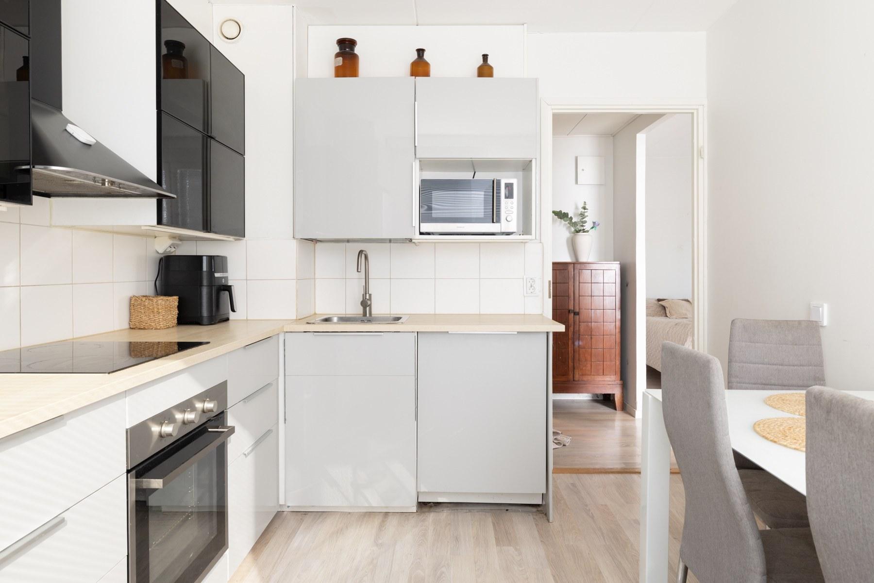 Keittiö ikkunaseinältä eteiseen päin kuvattuna