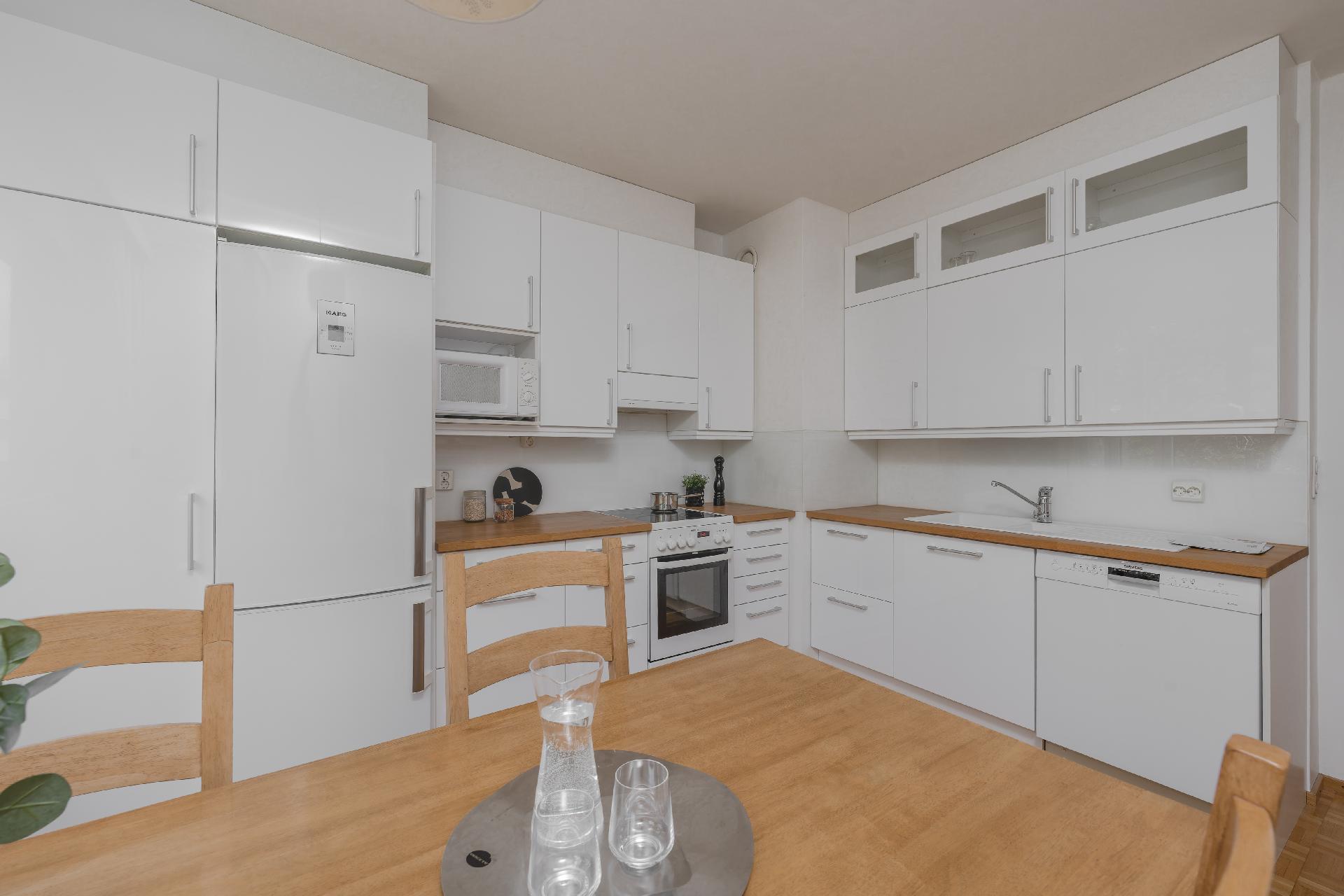 Remontoitu keittiö, jossa on runsaasti kaappitilaa ja tilaa ruokapöydälle