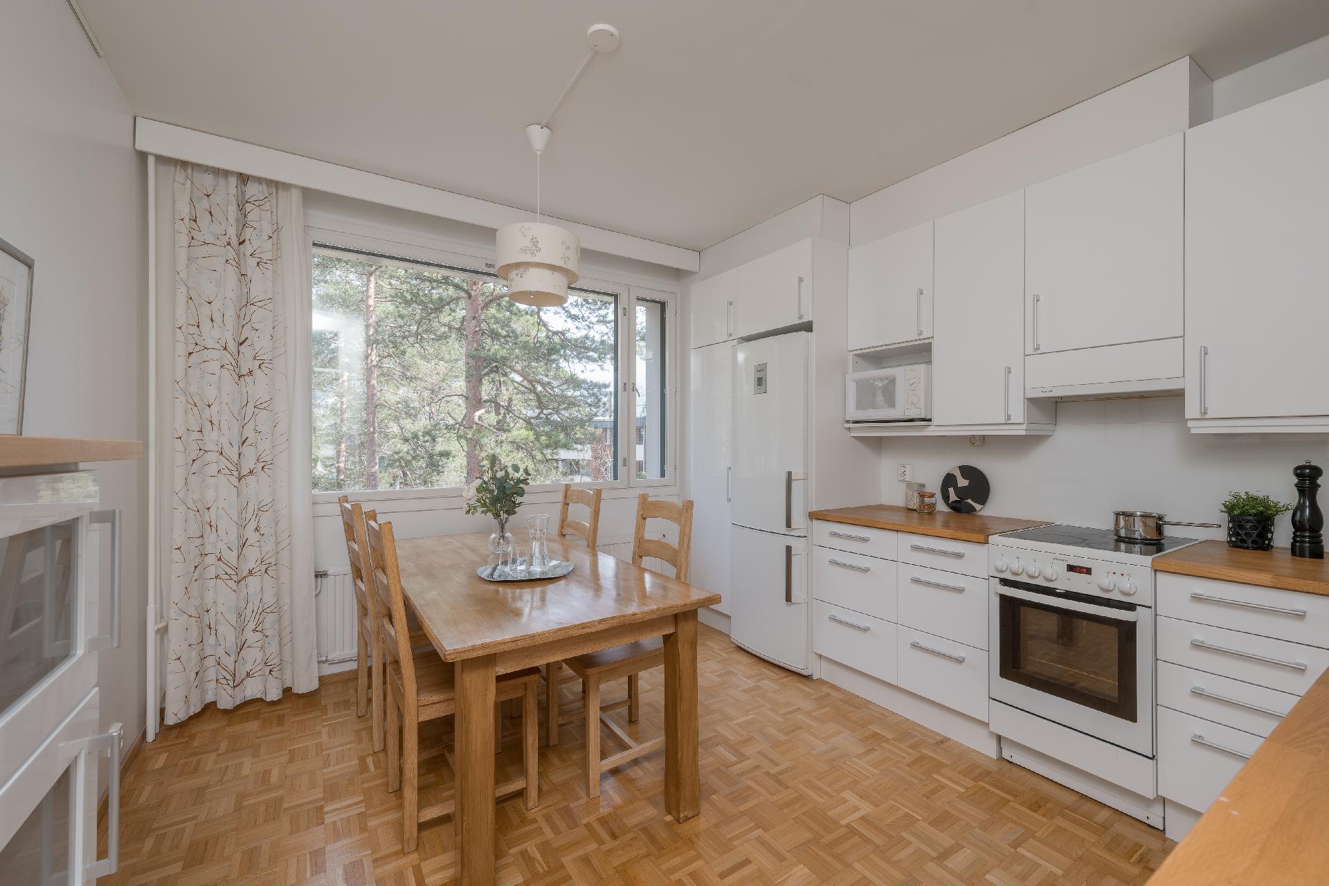 Remontoitu keittiö, jossa on runsaasti kaappitilaa ja tilaa ruokapöydälle