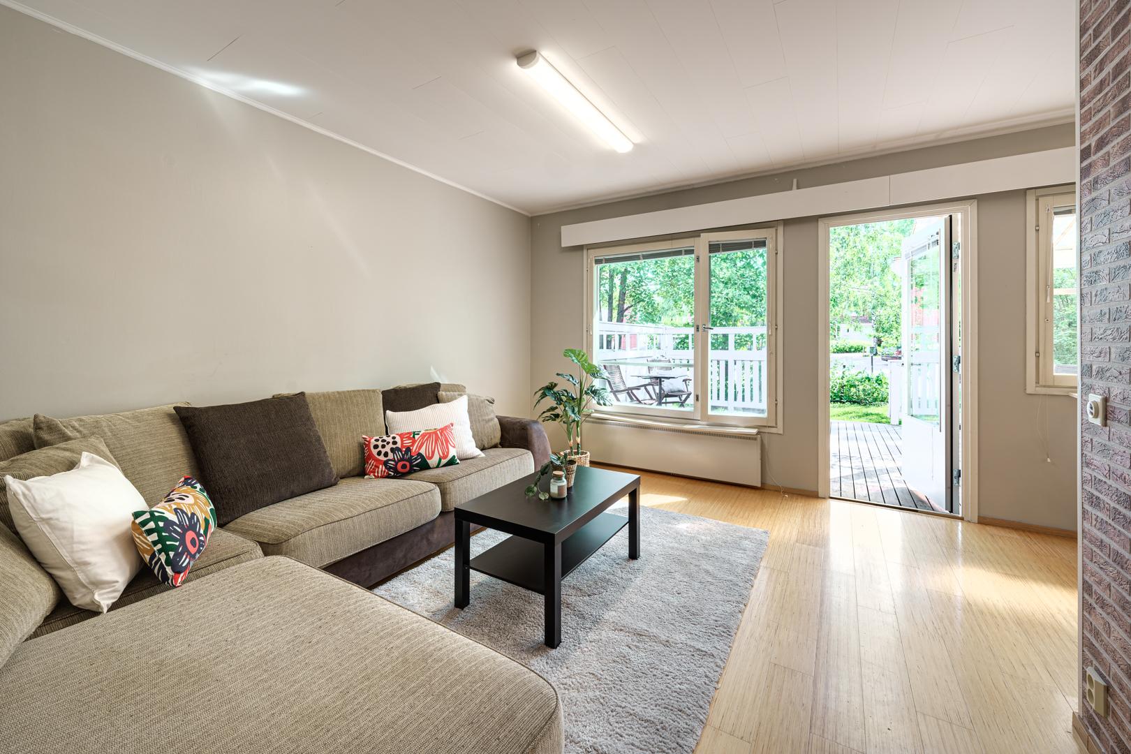 Valoisa olohuone, josta on käynti eteläpihalle