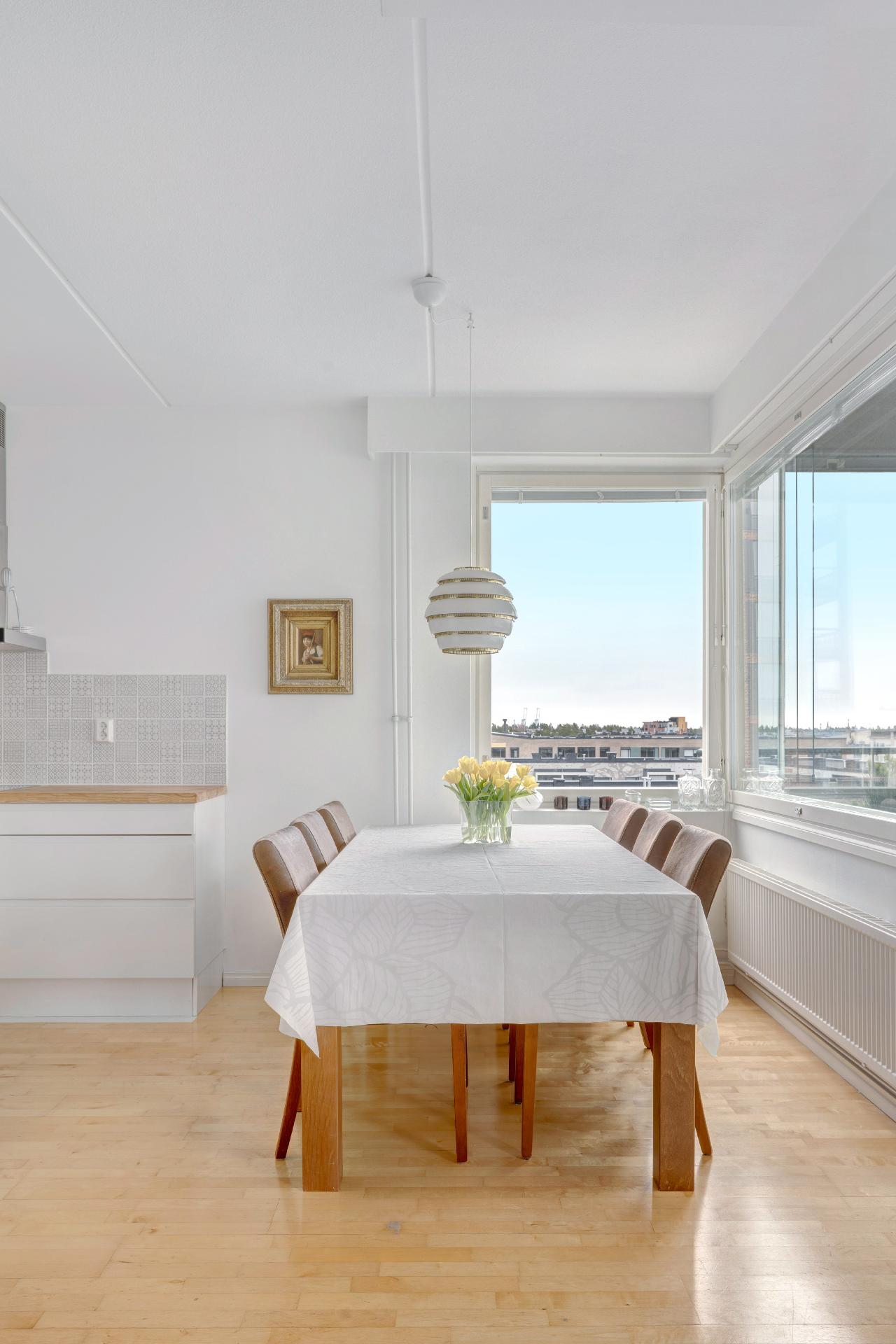 Ruokailutila suurien ikkunoiden ääressä