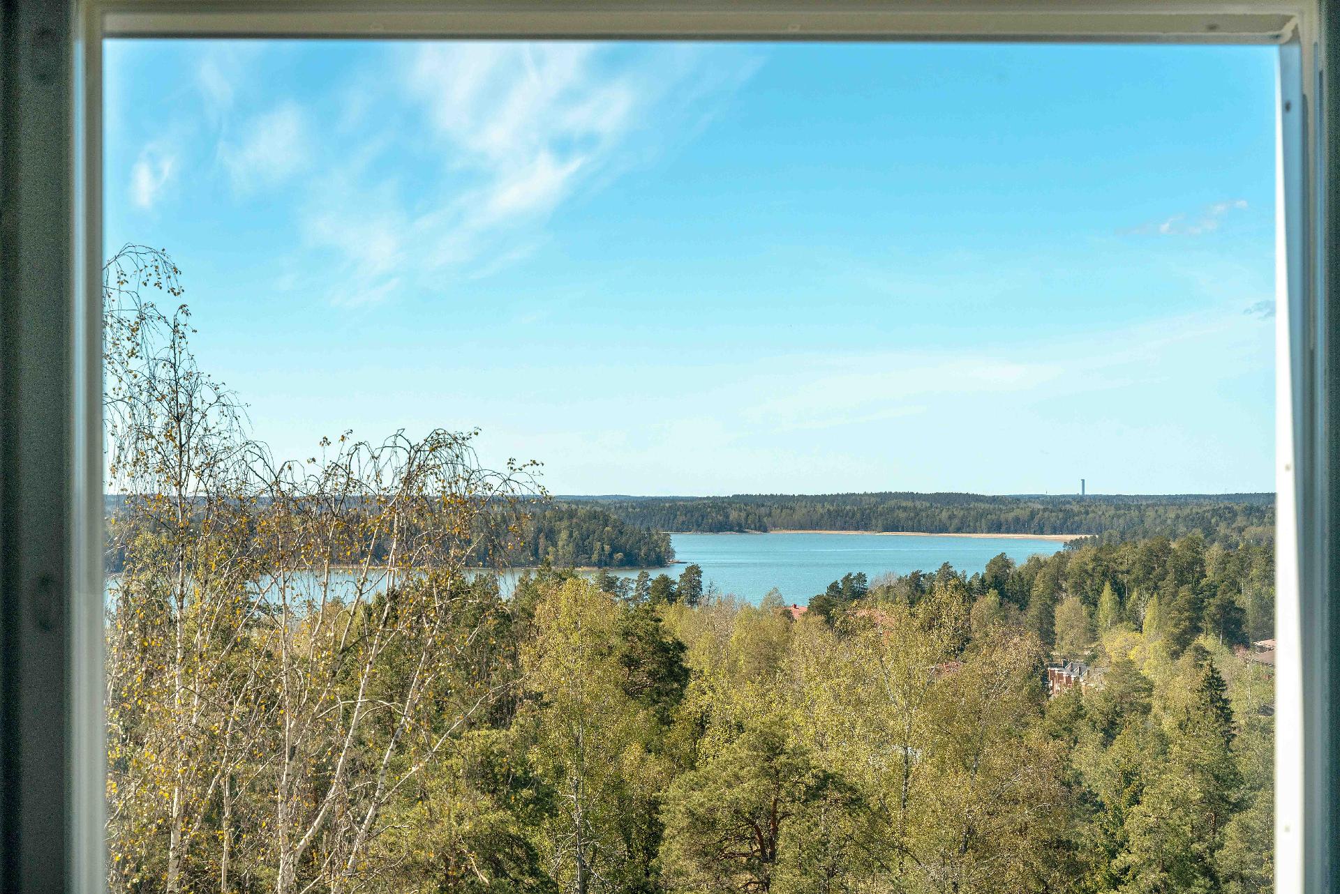 Makuuhuoneen avarat maisemat merelle talojen ja puiden yli.